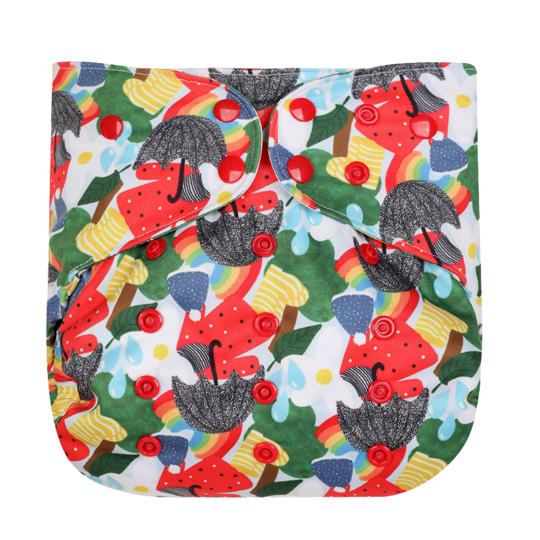 Image shows front of a reusable nappy wrap with popper fastenings and pattern of umbrellas, wellies, splashes, jumpers, wooly hats and flowers in reds, blues, yellows, whites.