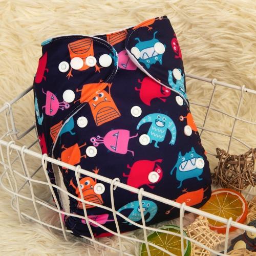 dark blue pocket nappy with blue orange and pink monsters on a dark green table