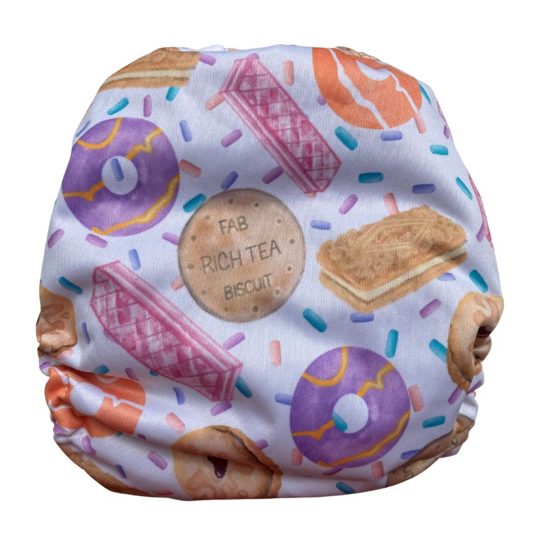 Reverse view of a PUL nappy wrap with a pastel pattern of traditional British biscuits including Digestive and Pink Wafer