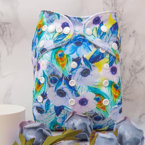 Light background pocket nappy with peacock feathers and lilac flowers in a white basket