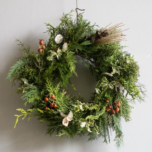 Circular foliage and winter berry wreath in natural colours of green and red