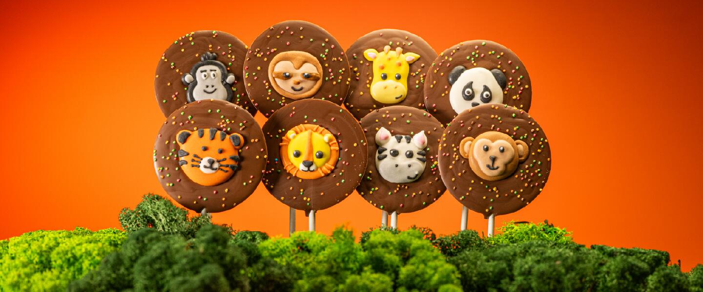 A set of Zoo themed iced animal toppers and sprinkles on milk Belgian chocolate lollies.