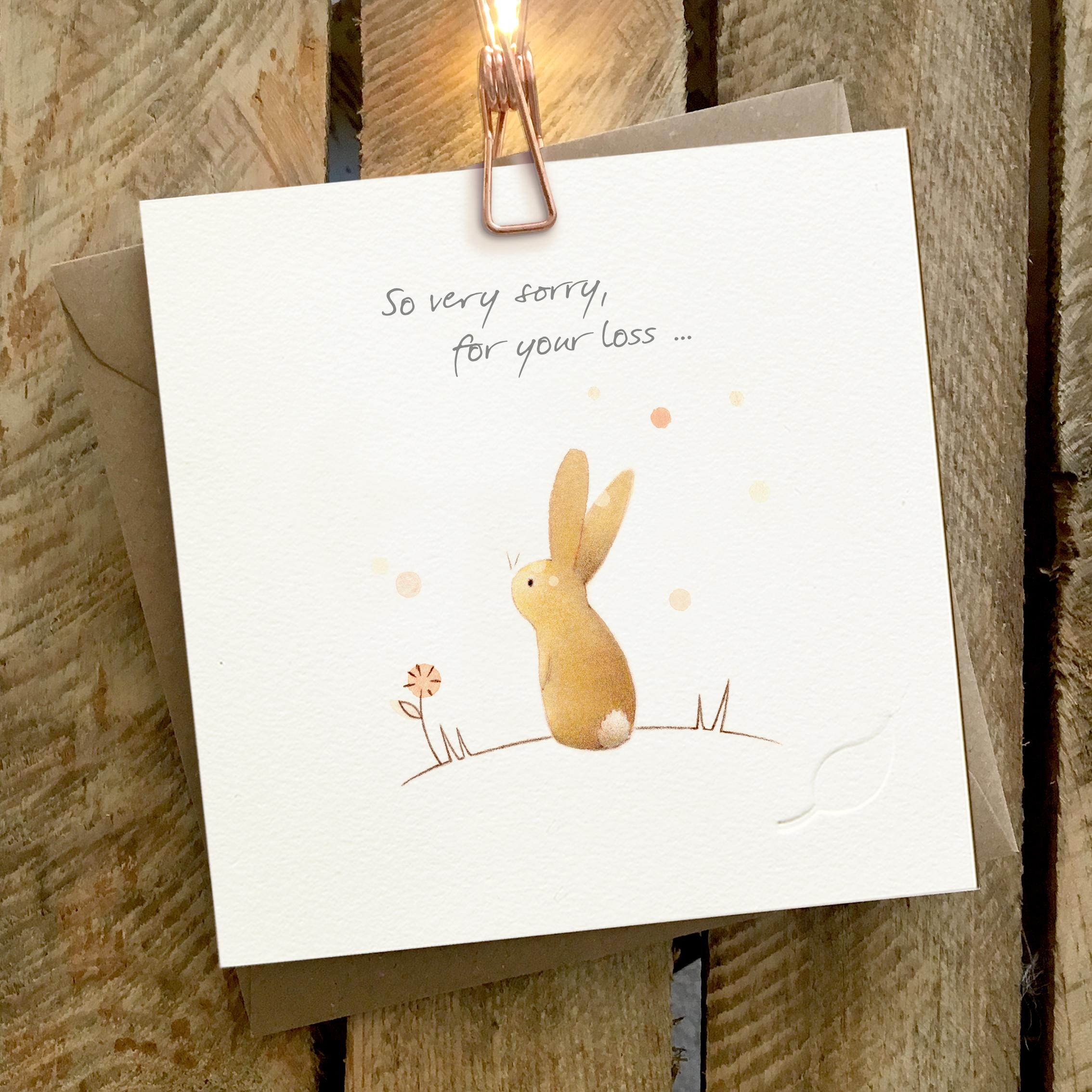 Card featuring a rabbit sitting on top of a little hill