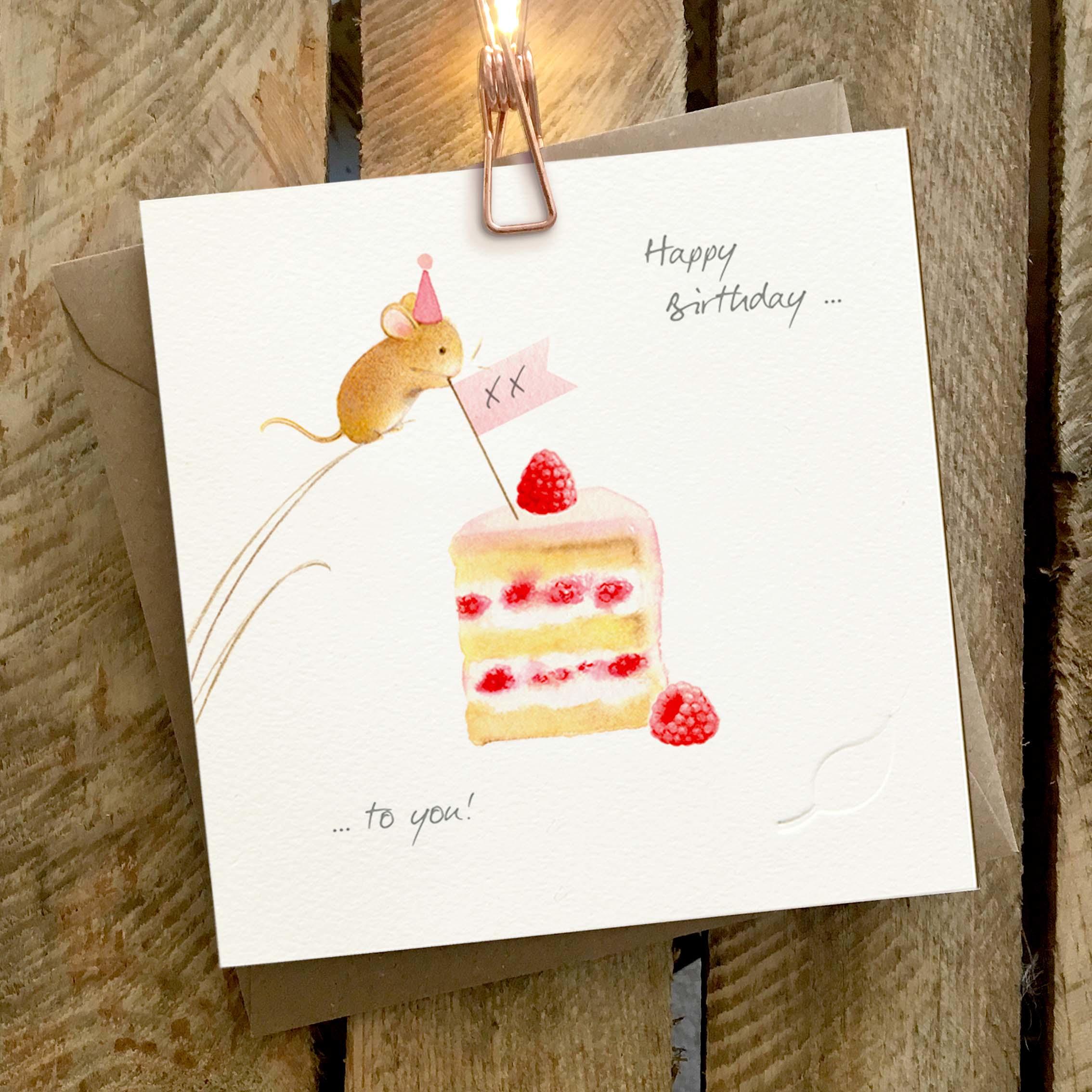 Card featuring a cute mouse placing a flag with kisses onto a slice of strawberry cream cake.