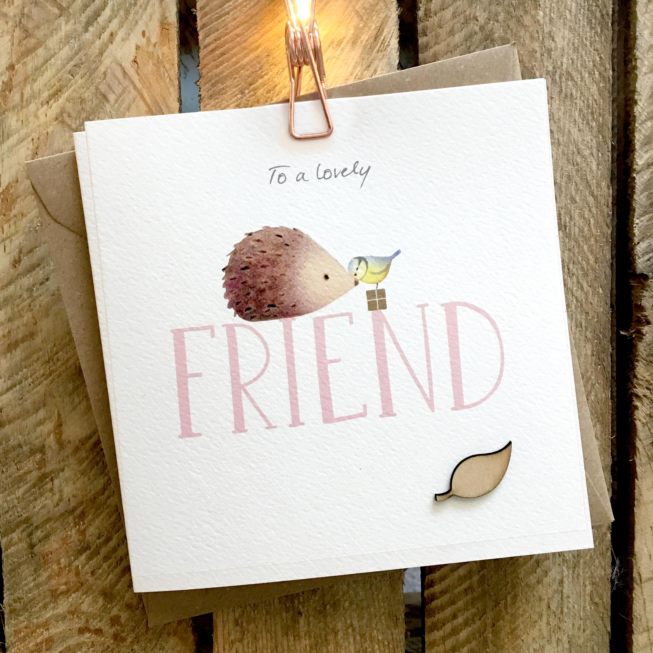 Card featuring a cute hedgehog and blue tit sitting on top of large FRIEND caption