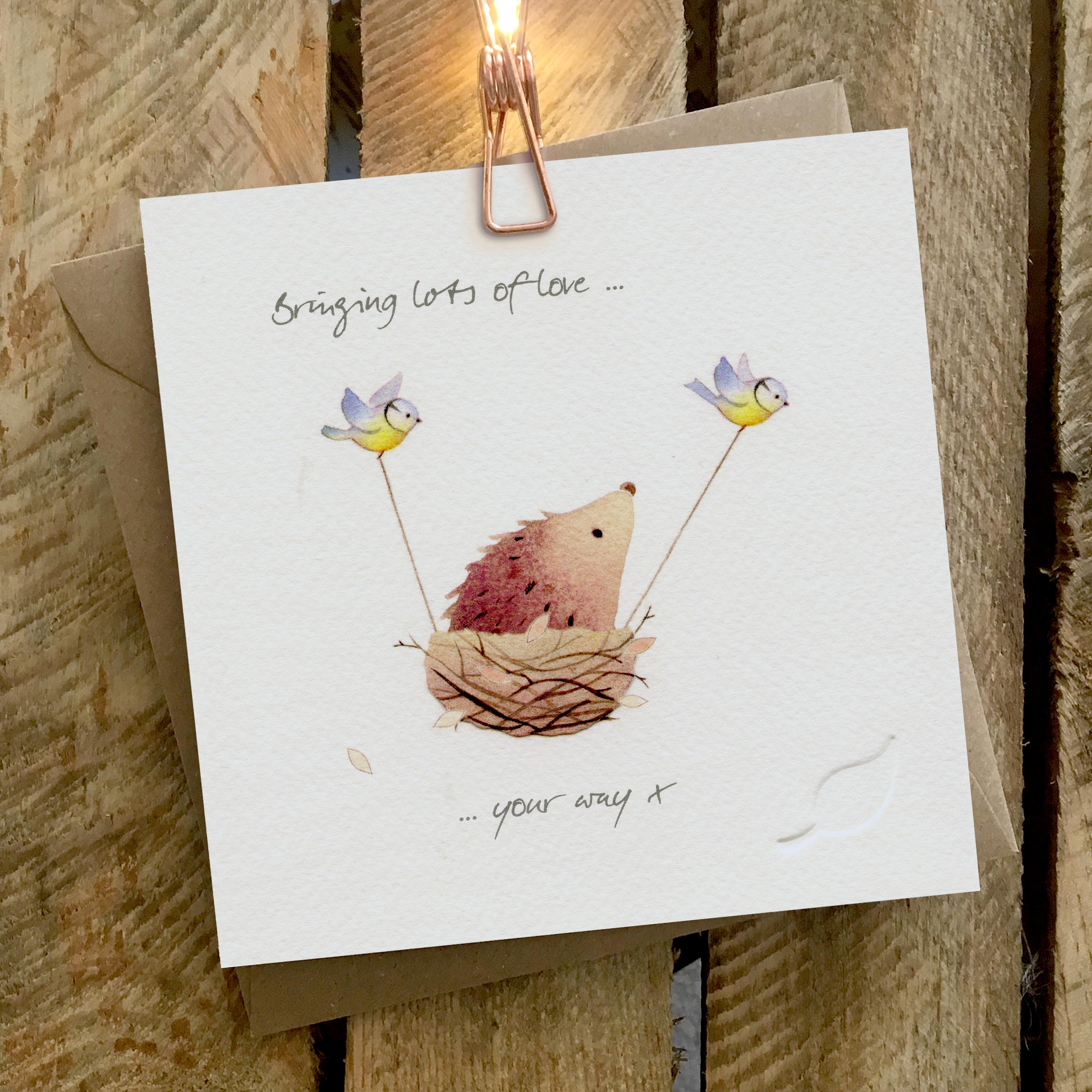 Card featuring two little birds carrying a hedgehog in a birds nest