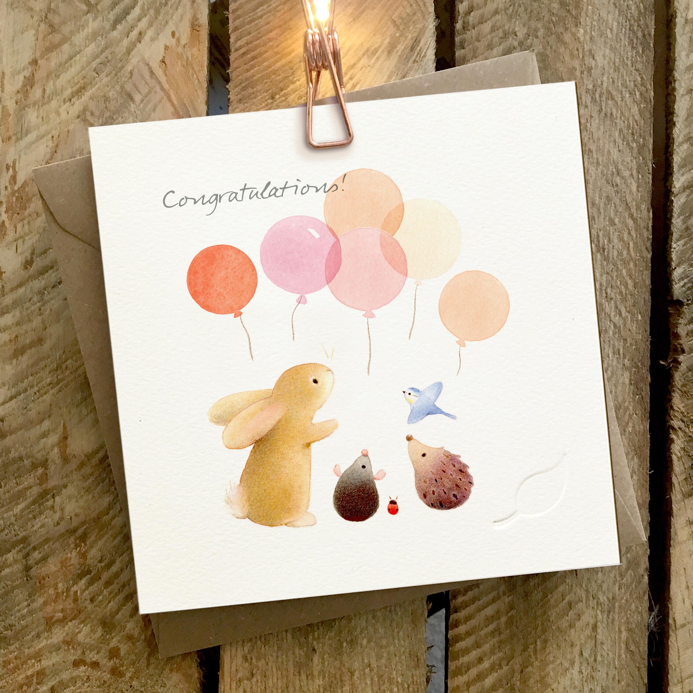 Card featuring a group of cute animals with balloons. Caption reads “Congratulations”