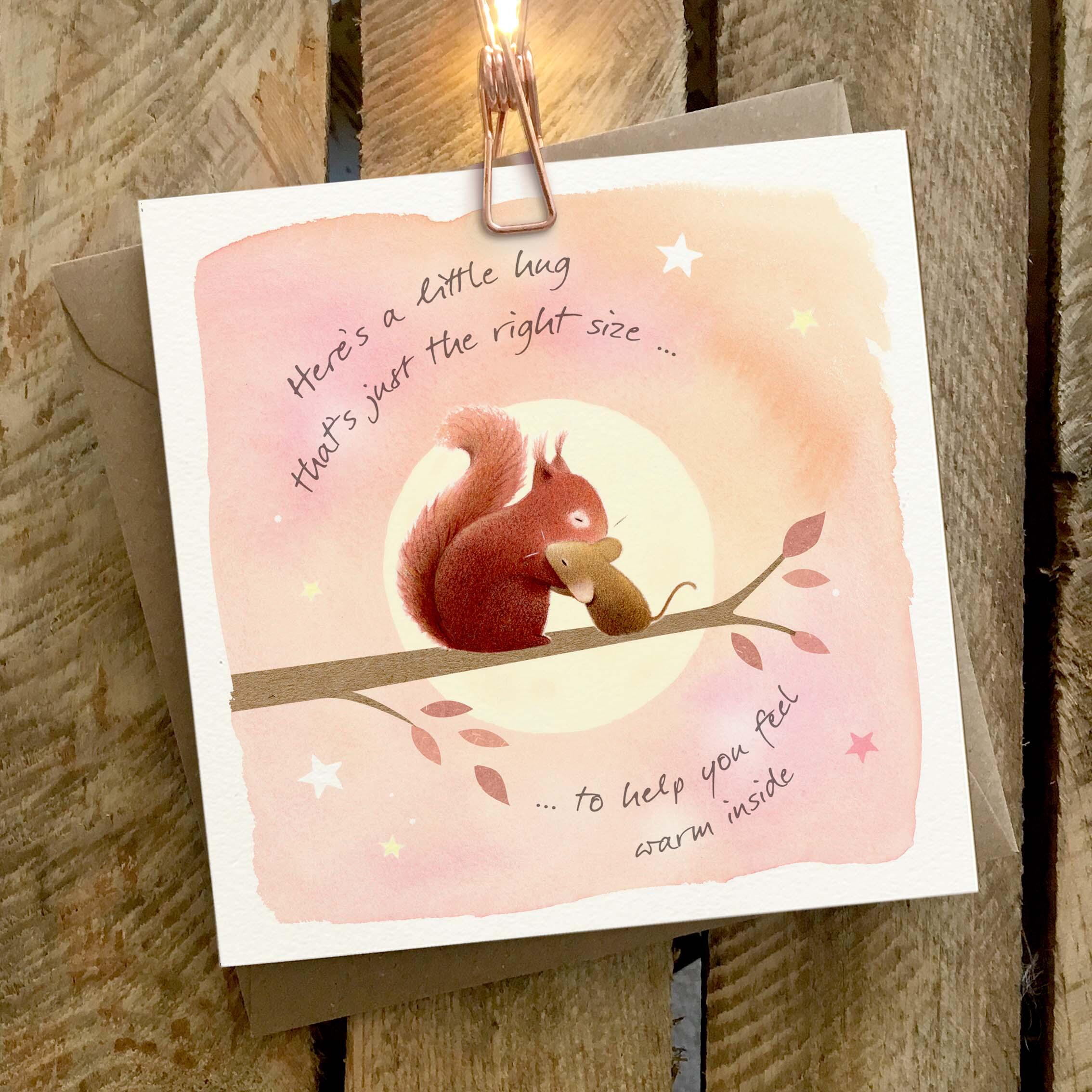Greetings card featuring a squirrel and a mouse hugging on a branch.