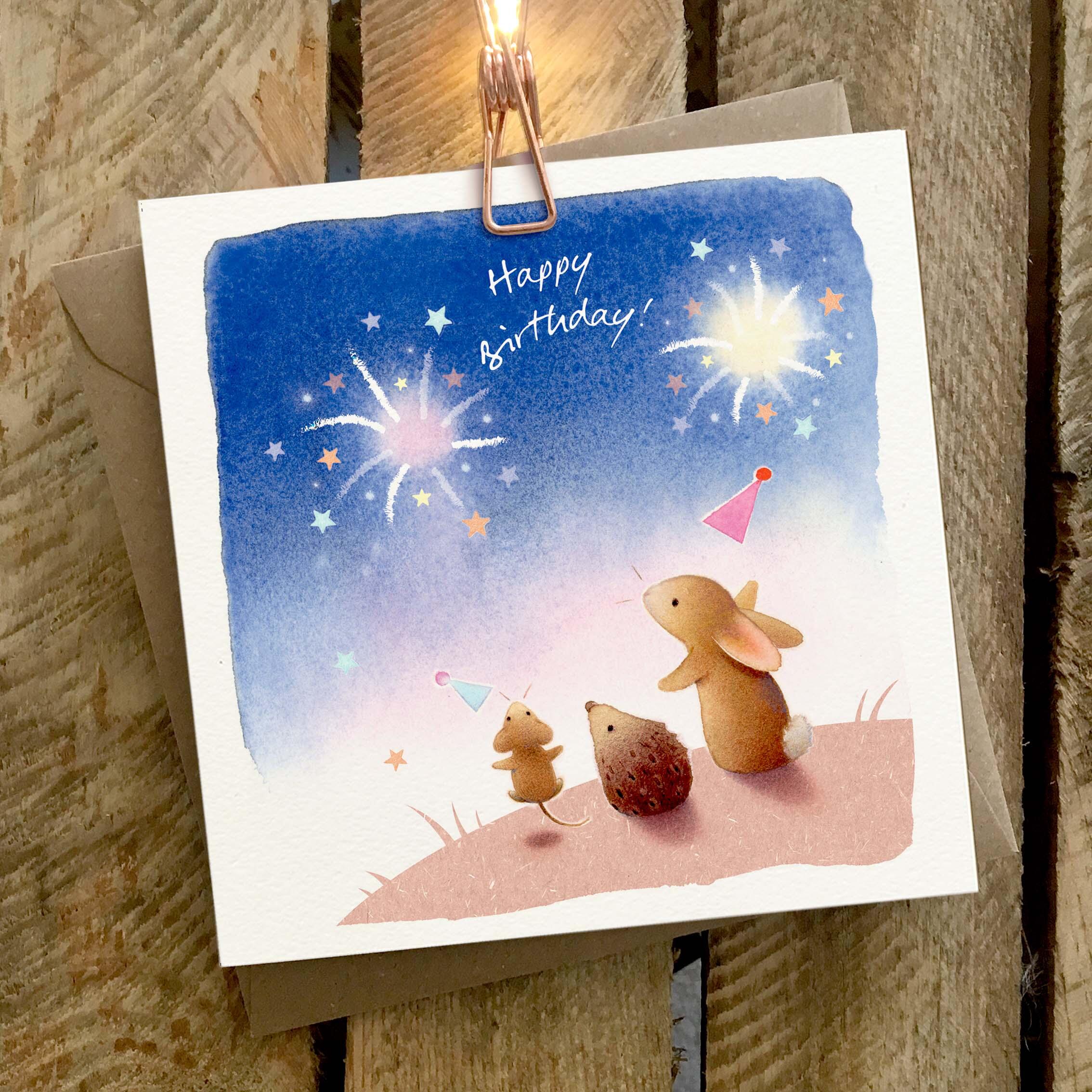 Greetings card featuring animals celebrating and fireworks.