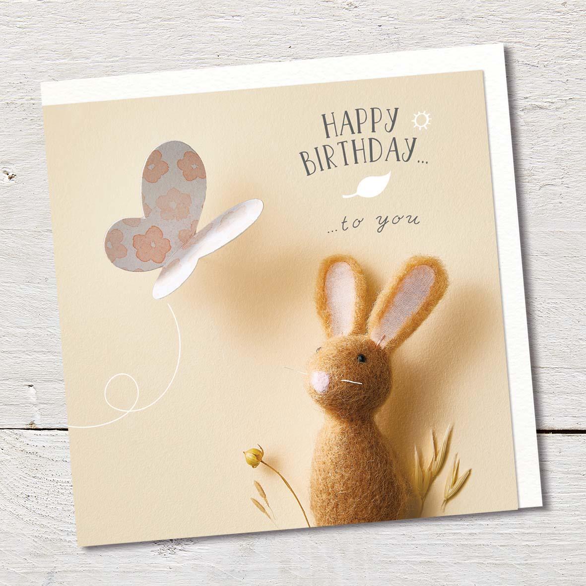 Card featuring a cute felted rabbit and a butterfly in the sunshine.