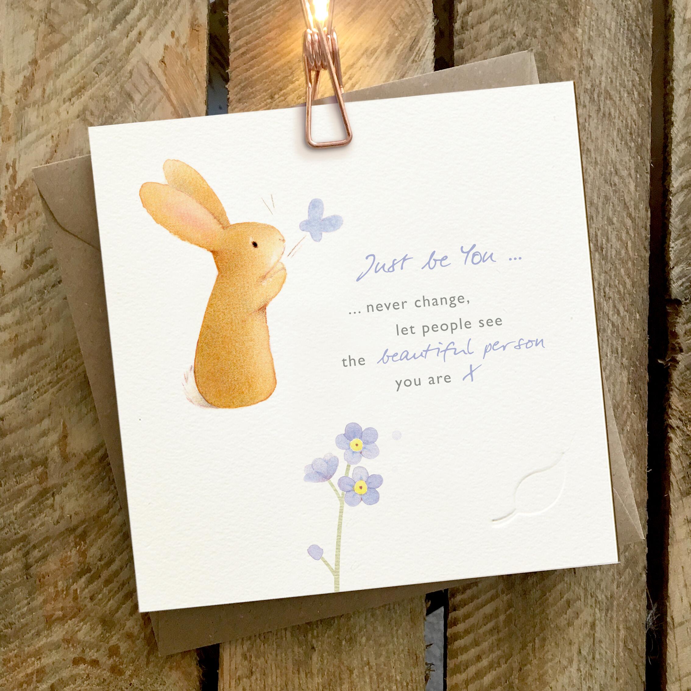 Card featuring a cute rabbit and blue flowers. Verse reads “Just be you… never change, let people see the beautiful person you are”