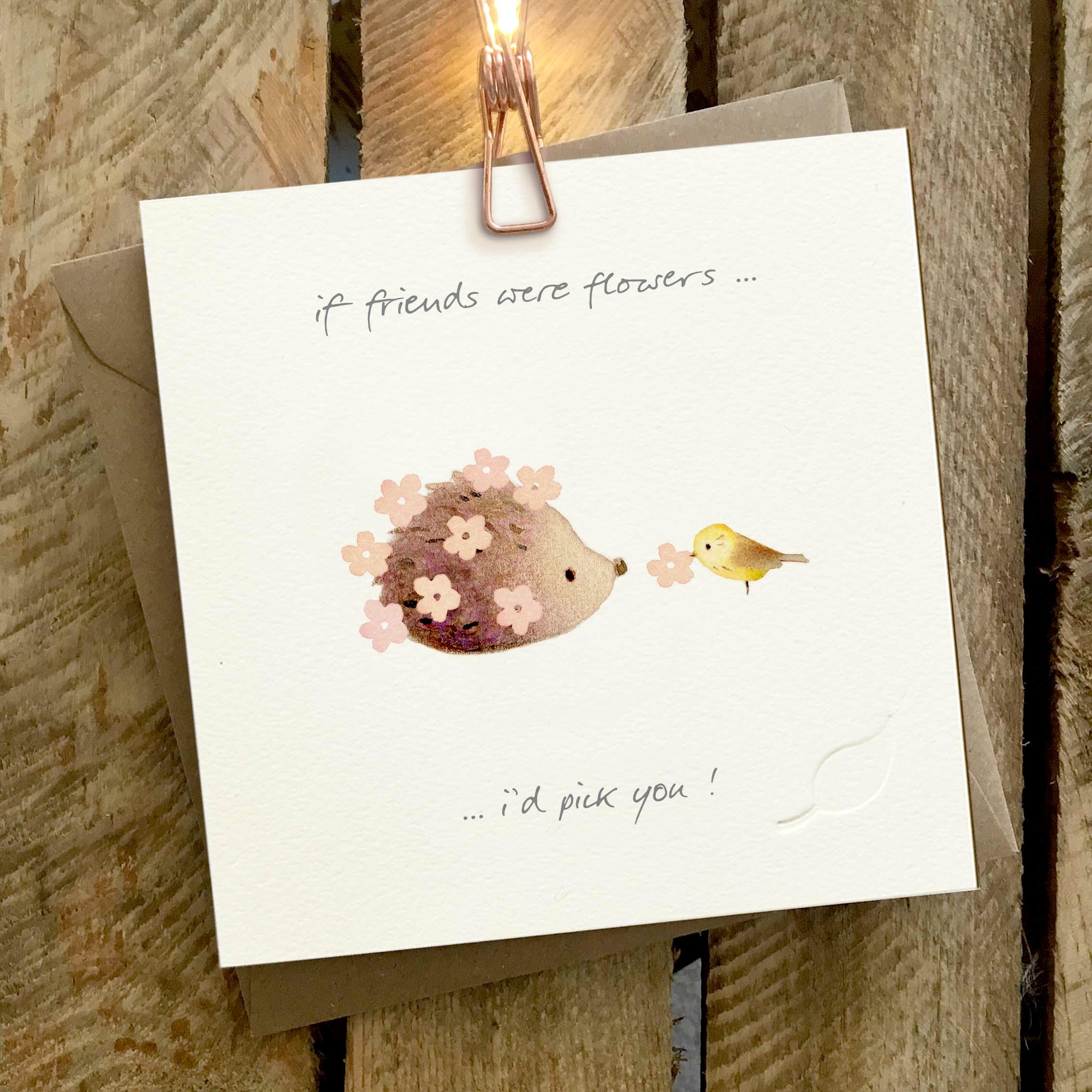 Card featuring a cute hedgehog covered in peach flowers, and a little yellow bird. Caption reads ‘If friends were flowers, I’d pick you’.