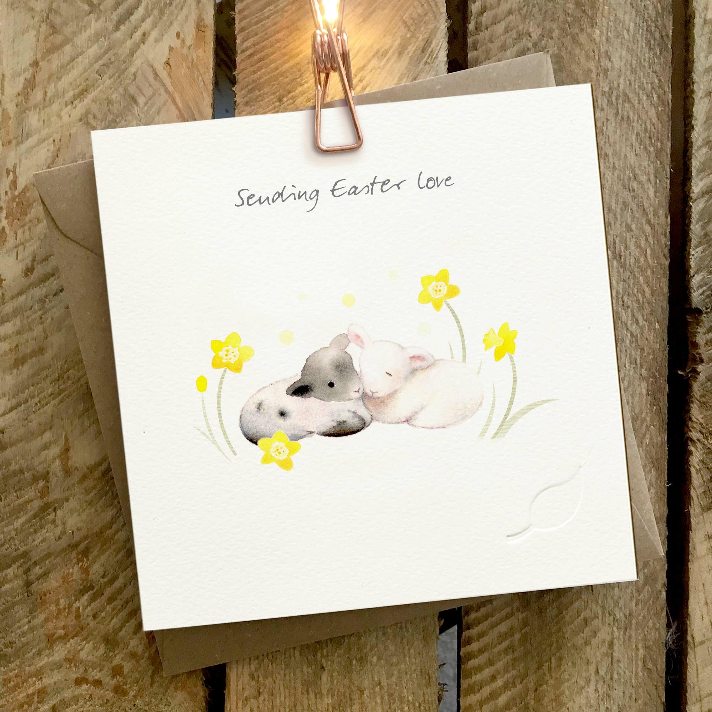 Card featuring two cute baby lambs and yellow flowers, with a ‘Sending Easter Love’ caption.