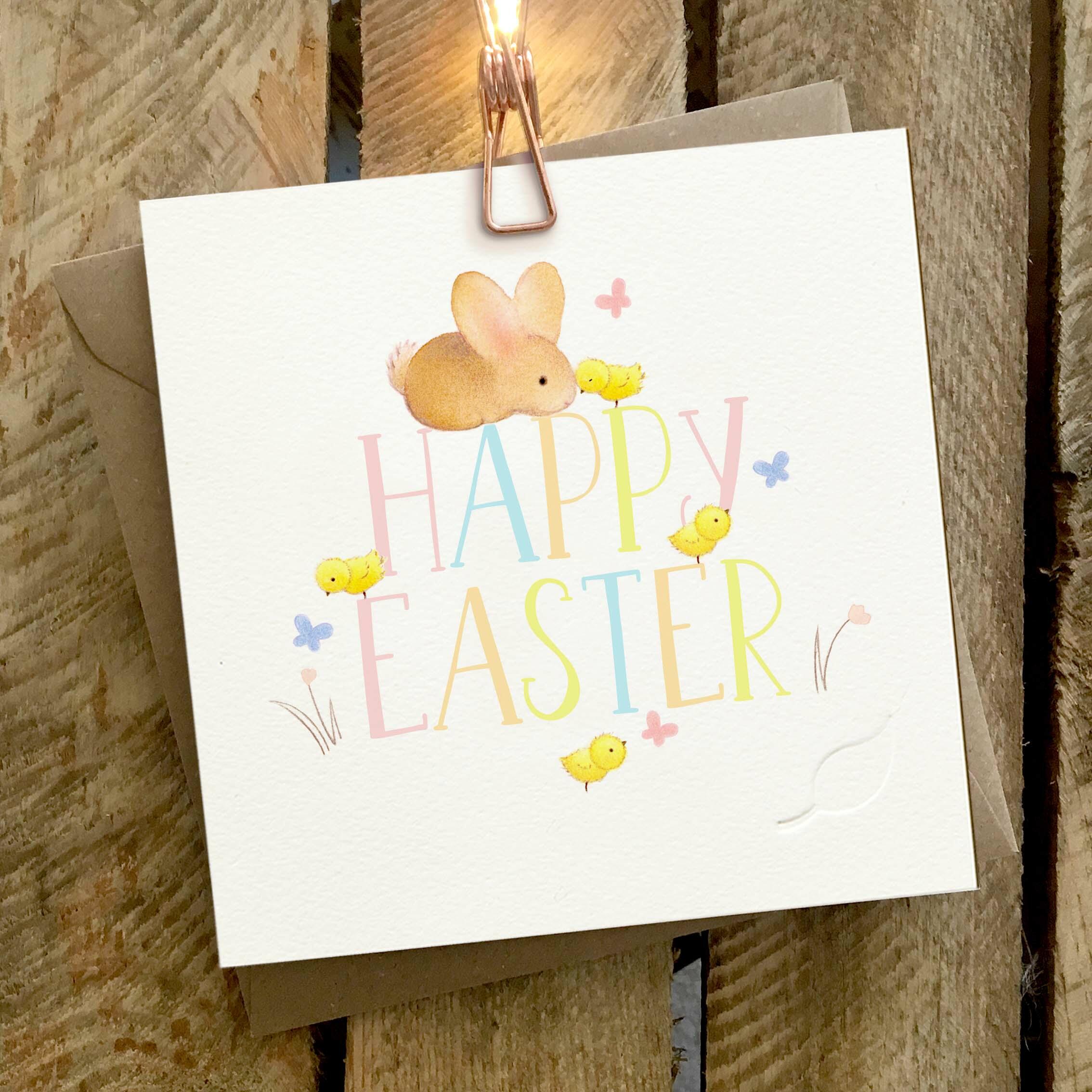 Card featuring a cute rabbit and yellow chicks, with a large multi coloured ‘Happy Easter’ caption.