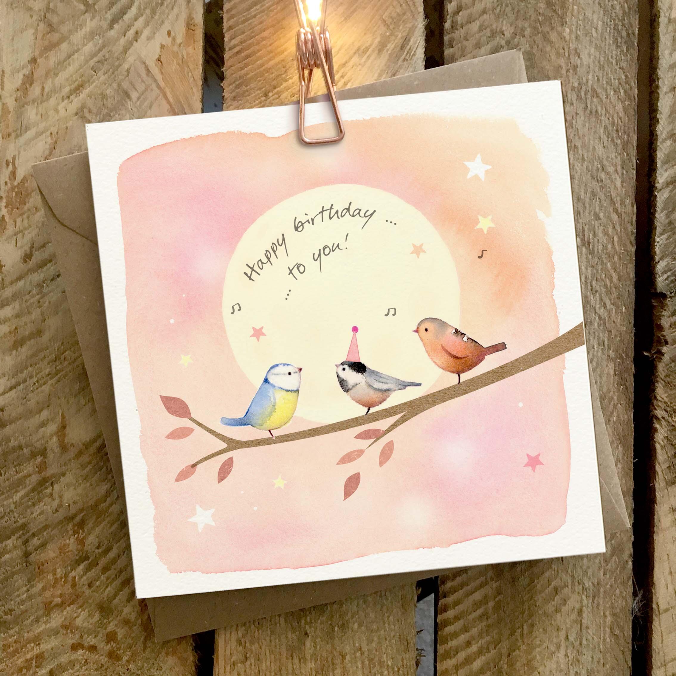 Greetings card featuring three little birds singing on a branch.