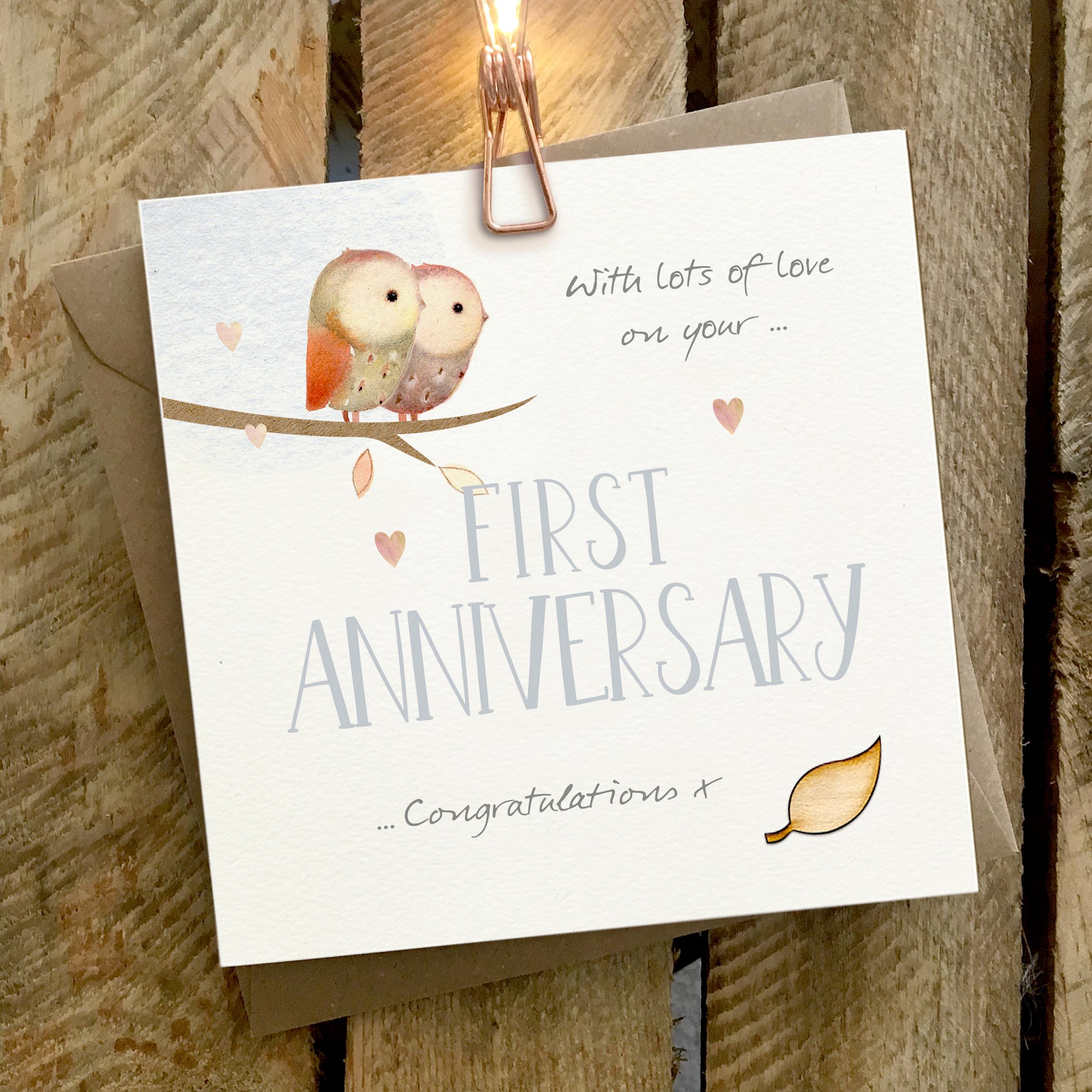 Card featuring two owls cuddling, and sitting on top of a large FIRST ANNIVERSARY caption