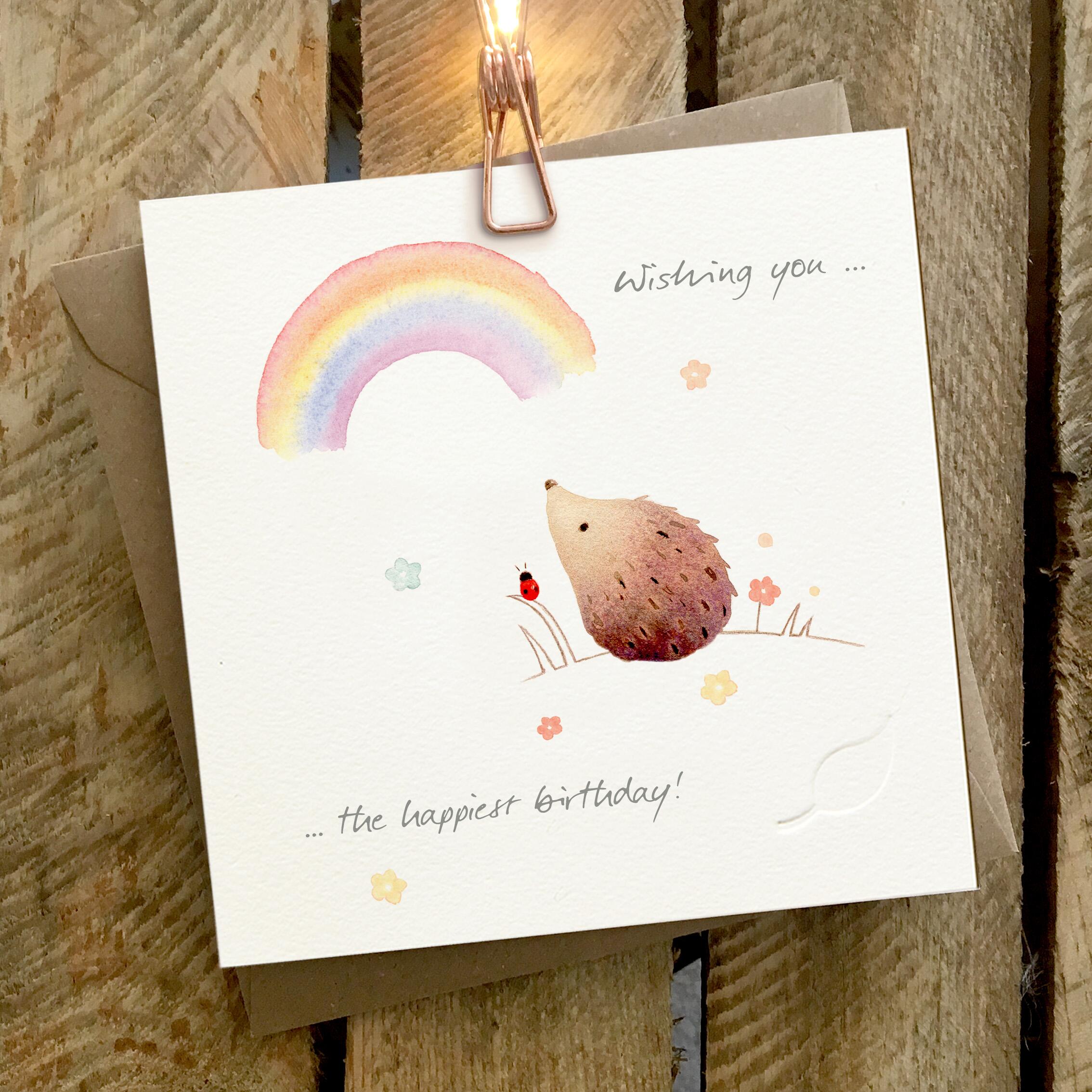 Card featuring a hedgehog and rainbow. Caption reads “Wishing You the Happiest Birthday”