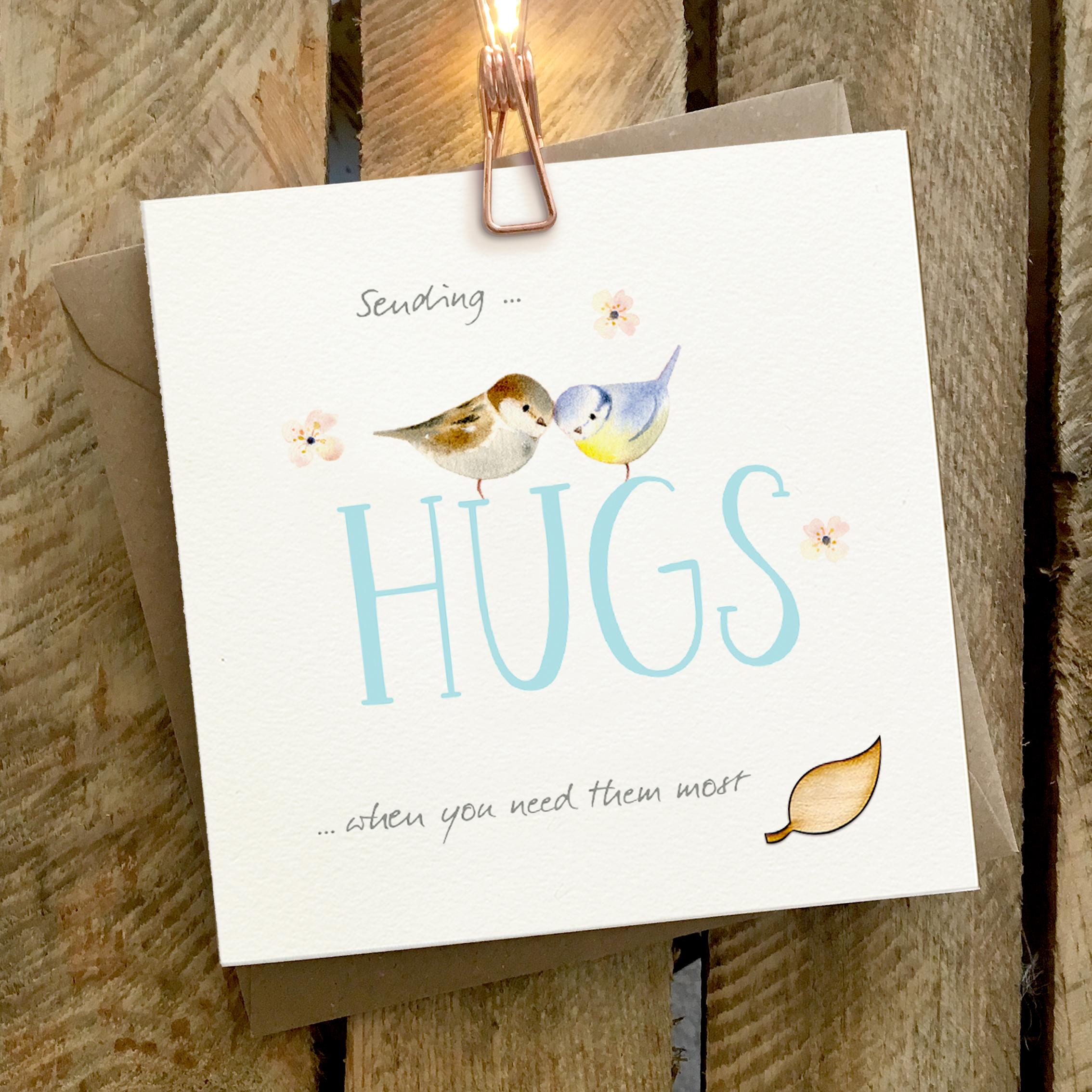 Card featuring two small birds sitting on top of a large HUGS caption