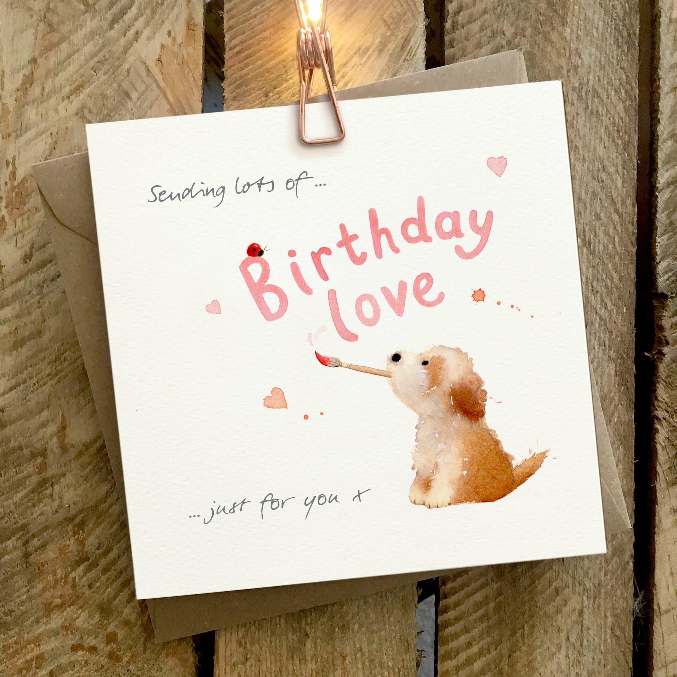 Card featuring a brown and white doodle dog painting a ‘Birthday Love’ caption.