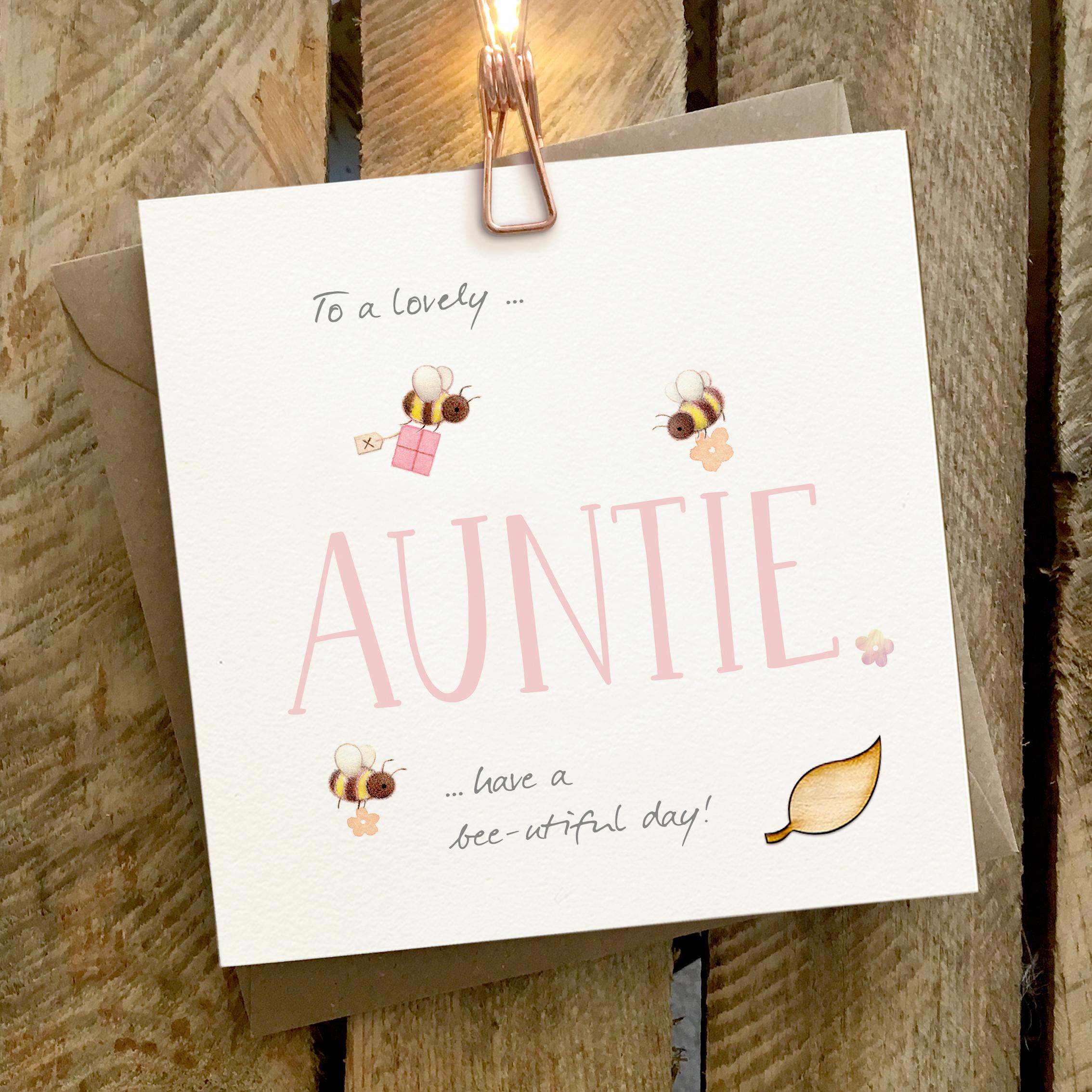 Card featuring bees carrying presents and flying around a large AUNTIE caption
