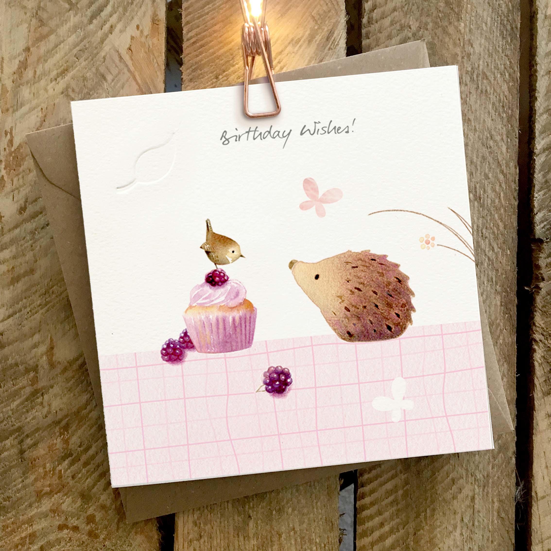 Card featuring a cute hedgehog with a bird sitting on top of a blackberry muffin.
