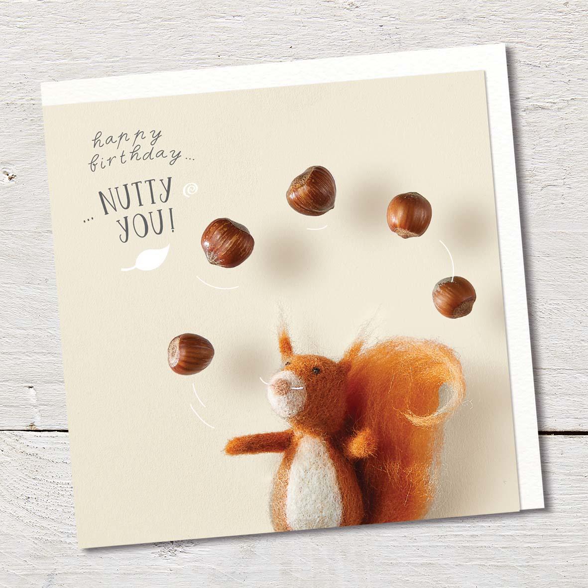 Card featuring a cute felted red squirrel juggling hazelnuts.