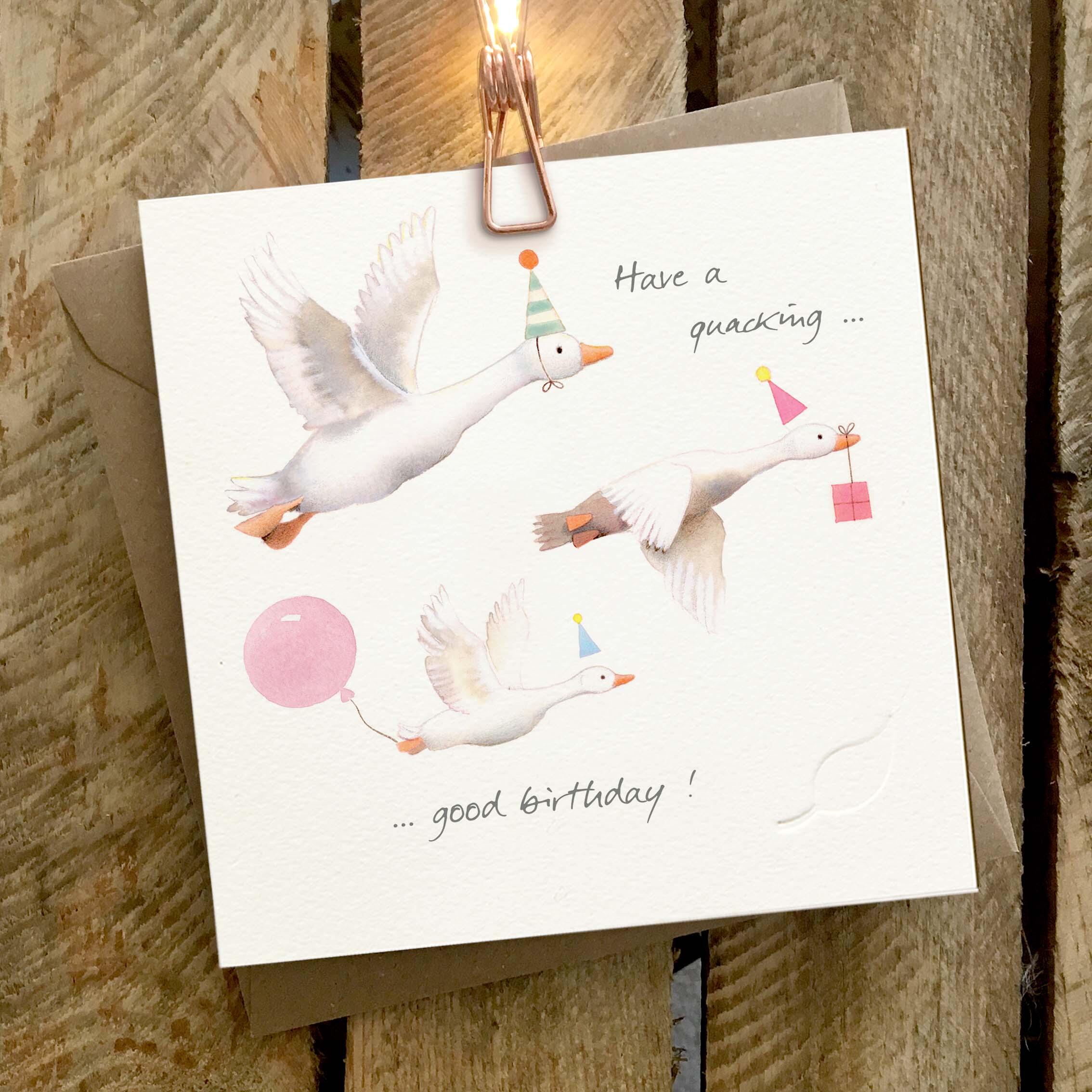 Card featuring three flying ducks wearing party hats and balloons. Caption reads ‘Have a quacking good birthday’.