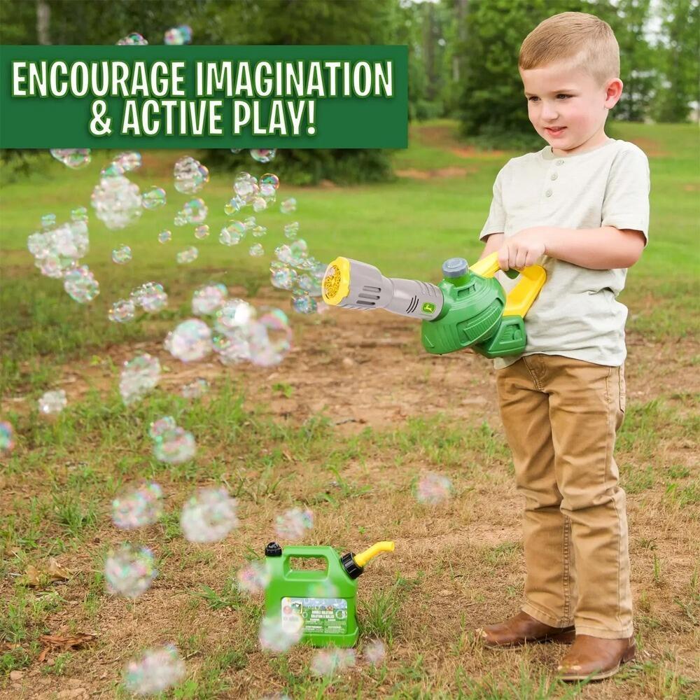boy playing with bubble blower toy outdoors in garden