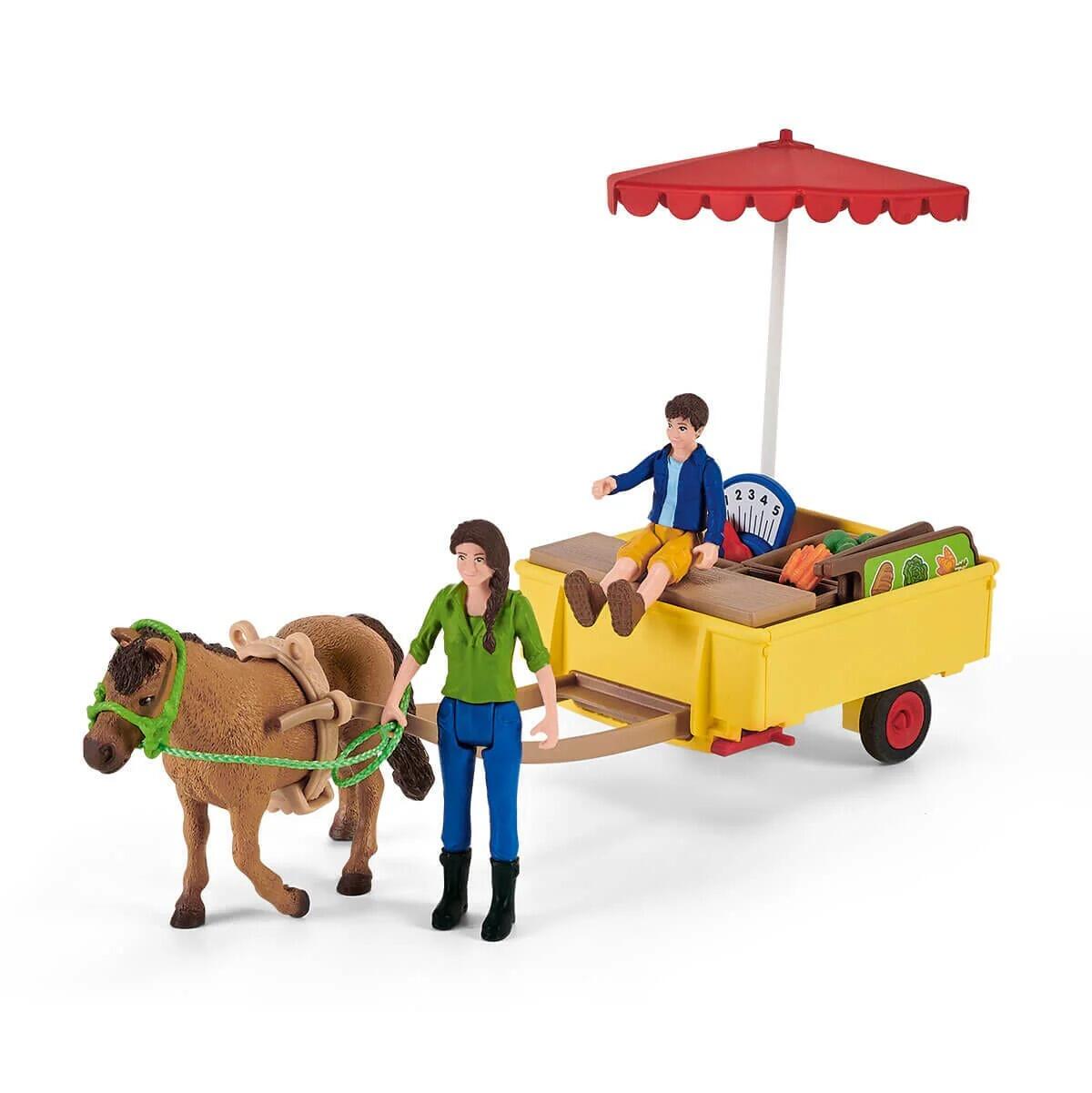 Schleich horse pulling the mobile farm stand with figure walking alongside.