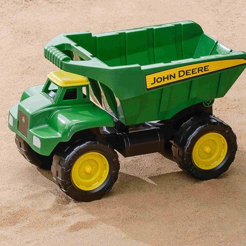 John Deere Big Scoop dump truck toy in green and yellow shown on sand.
