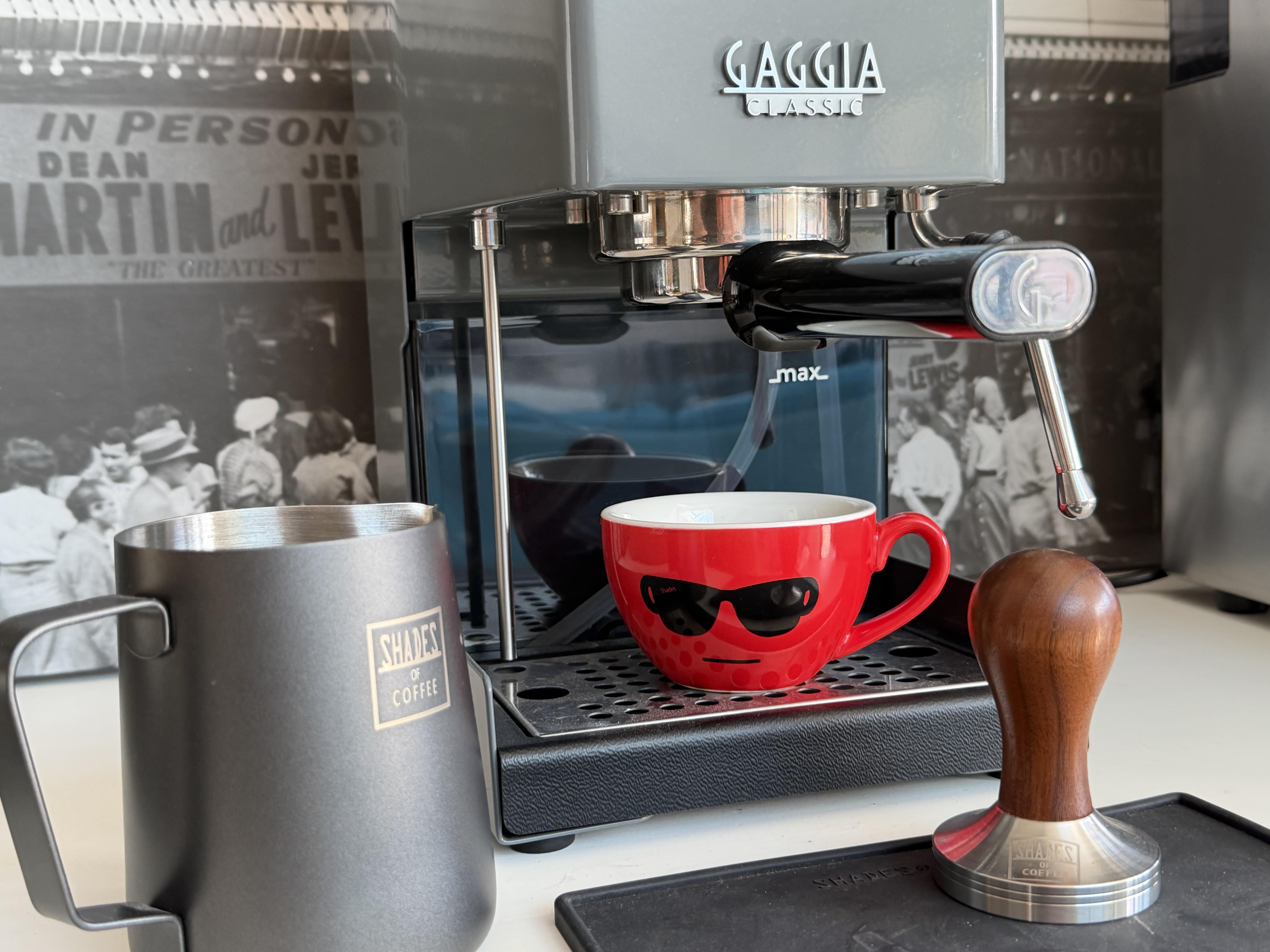 Gaggia Classic espresso machine with a red coffee cup, milk frothing jug, and tamper from Shades of Coffee