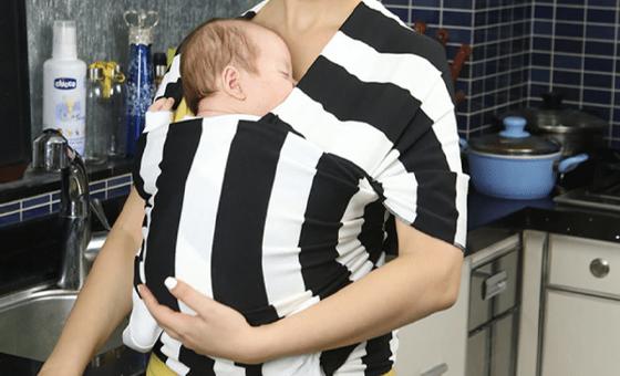a baby in a black and white striped baby carrier