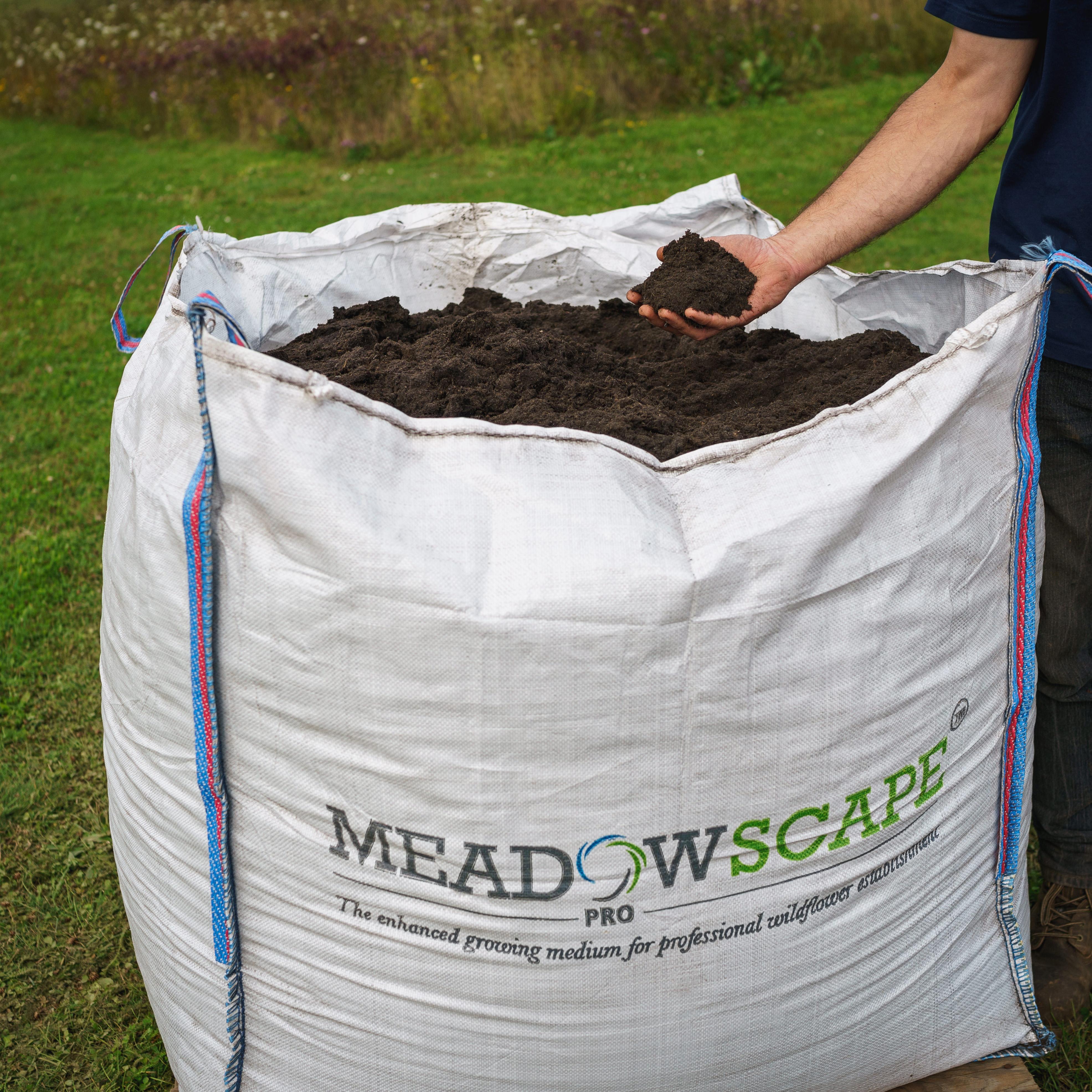 A dumpy bag of Meadowscape Pro with a hand holding some of the product