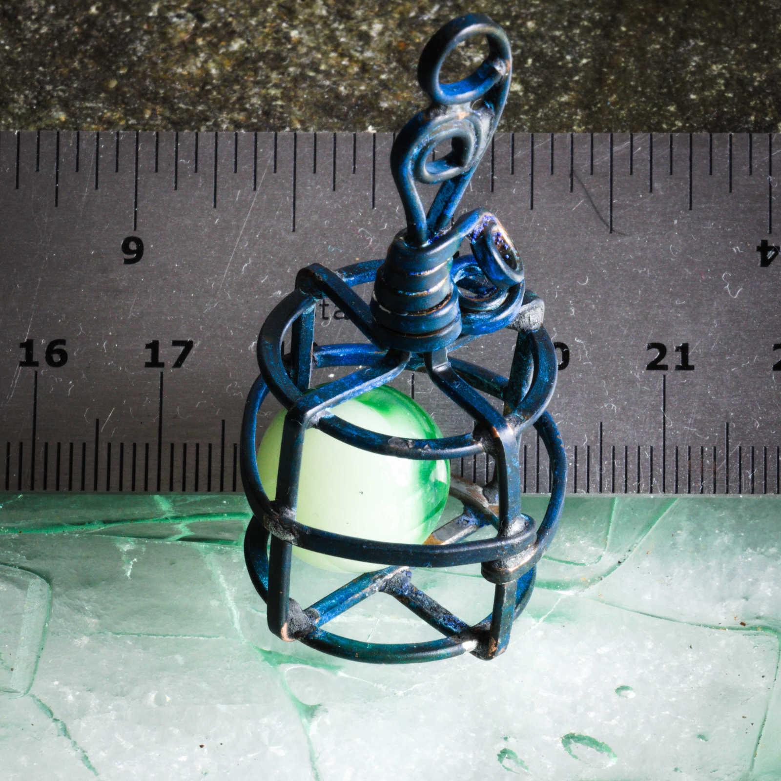 Captured in a cage, Uranium glass marble with ruler to show scale