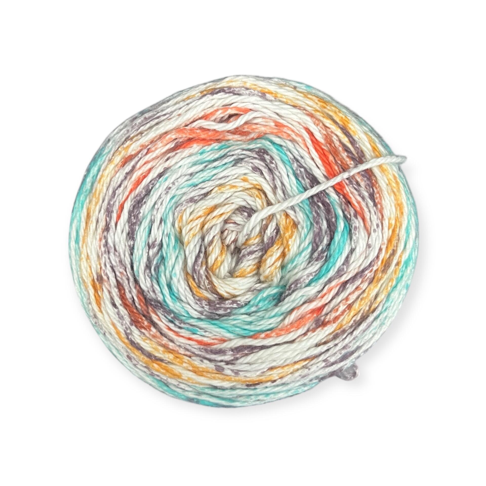 James C. Brett Cotton Waves yarn cake in Beach Days WV06 – 100% cotton DK yarn featuring aqua blue, soft grey, orange, and white tones.