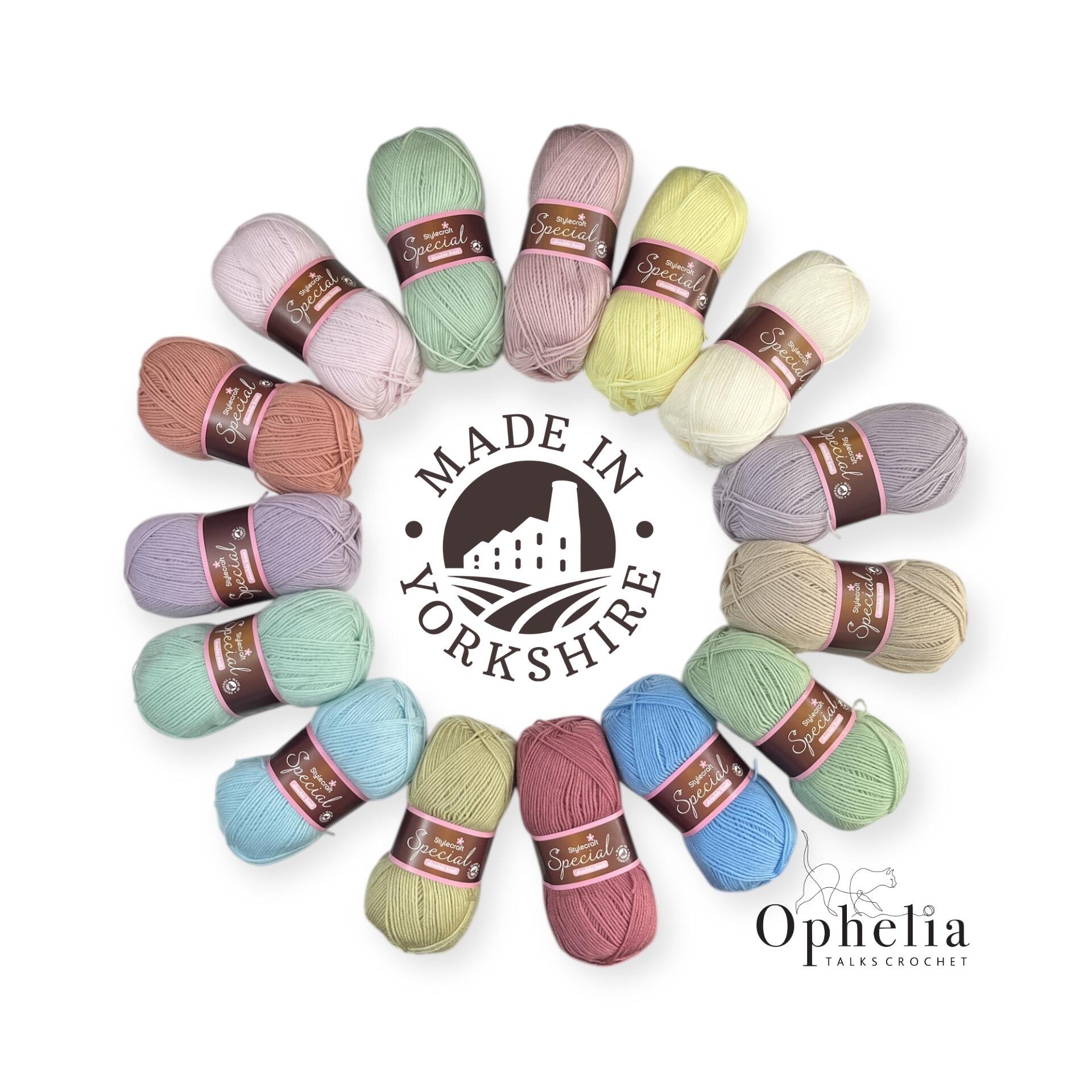 Flat-lay of 15 skeins of Stylecraft Special DK yarn in soft pastel shades (mint, blush, lavender, buttercup, sky blue, peach, cream) arranged in a circle on a white background.