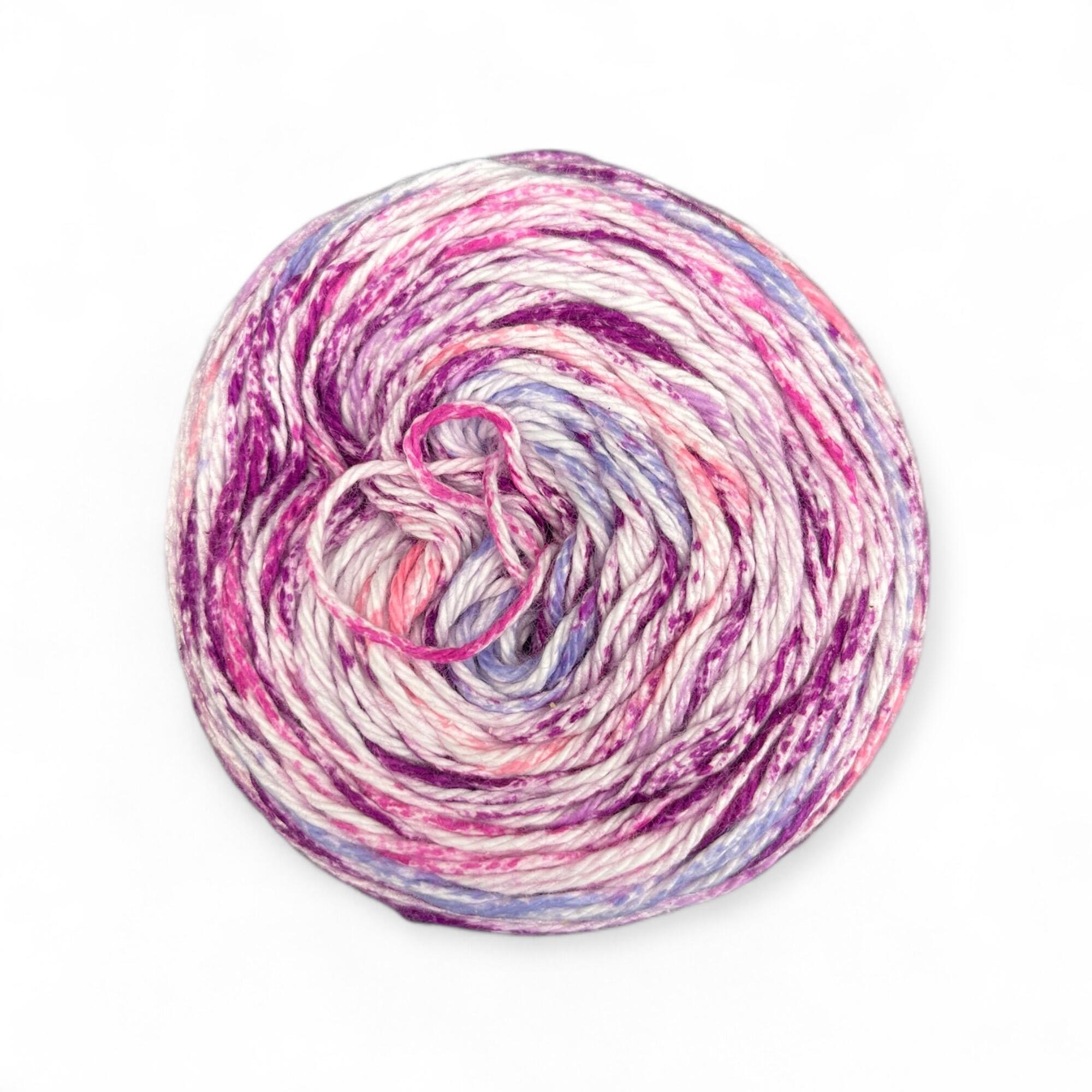 James C. Brett Cotton Waves yarn cake in Pretty Purples WV03 – DK-weight 100% cotton yarn with swirling shades of pink, lilac, and purple