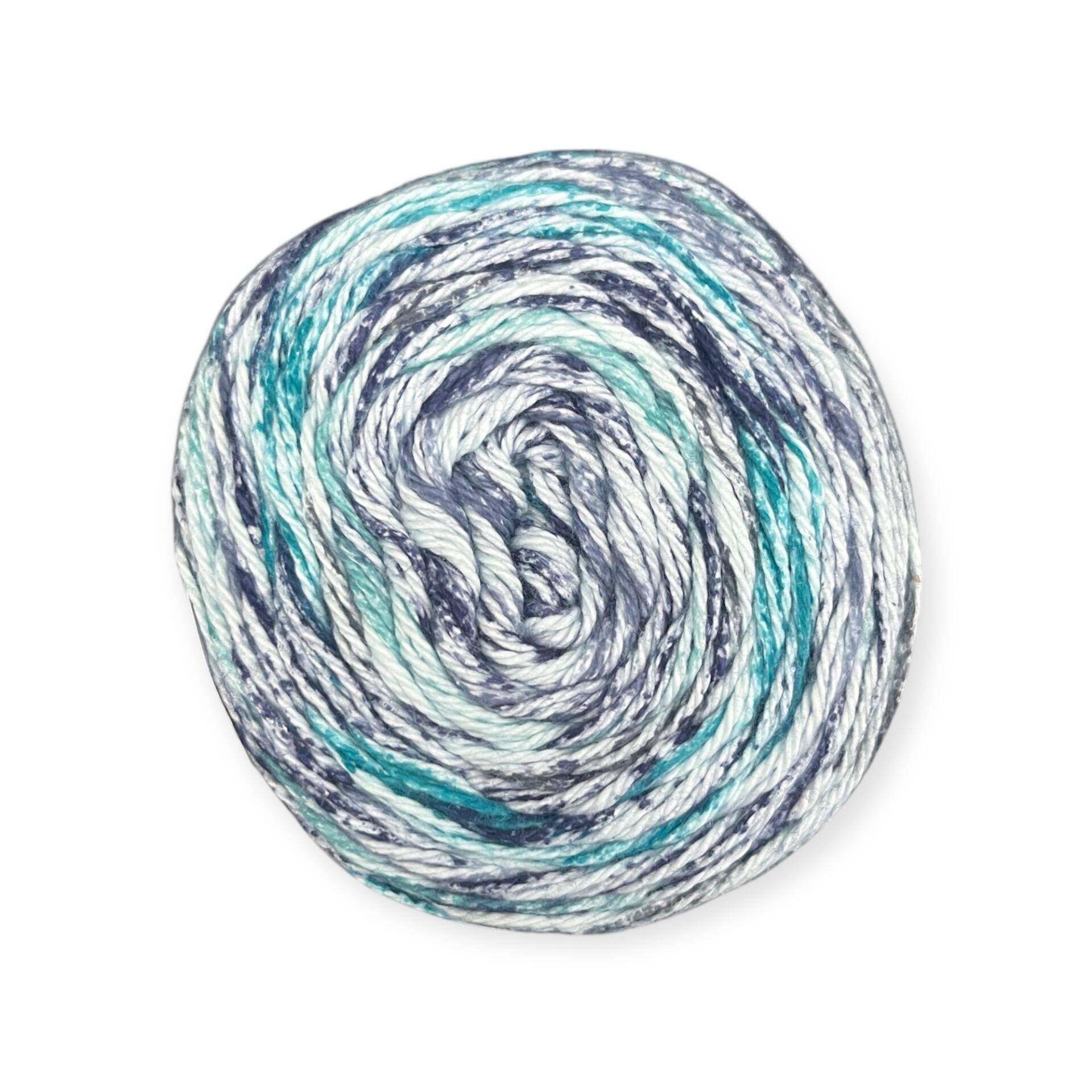 James C. Brett Cotton Waves yarn cake in Water’s Edge WV09 – 100% cotton DK yarn featuring shades of teal, navy blue, and white