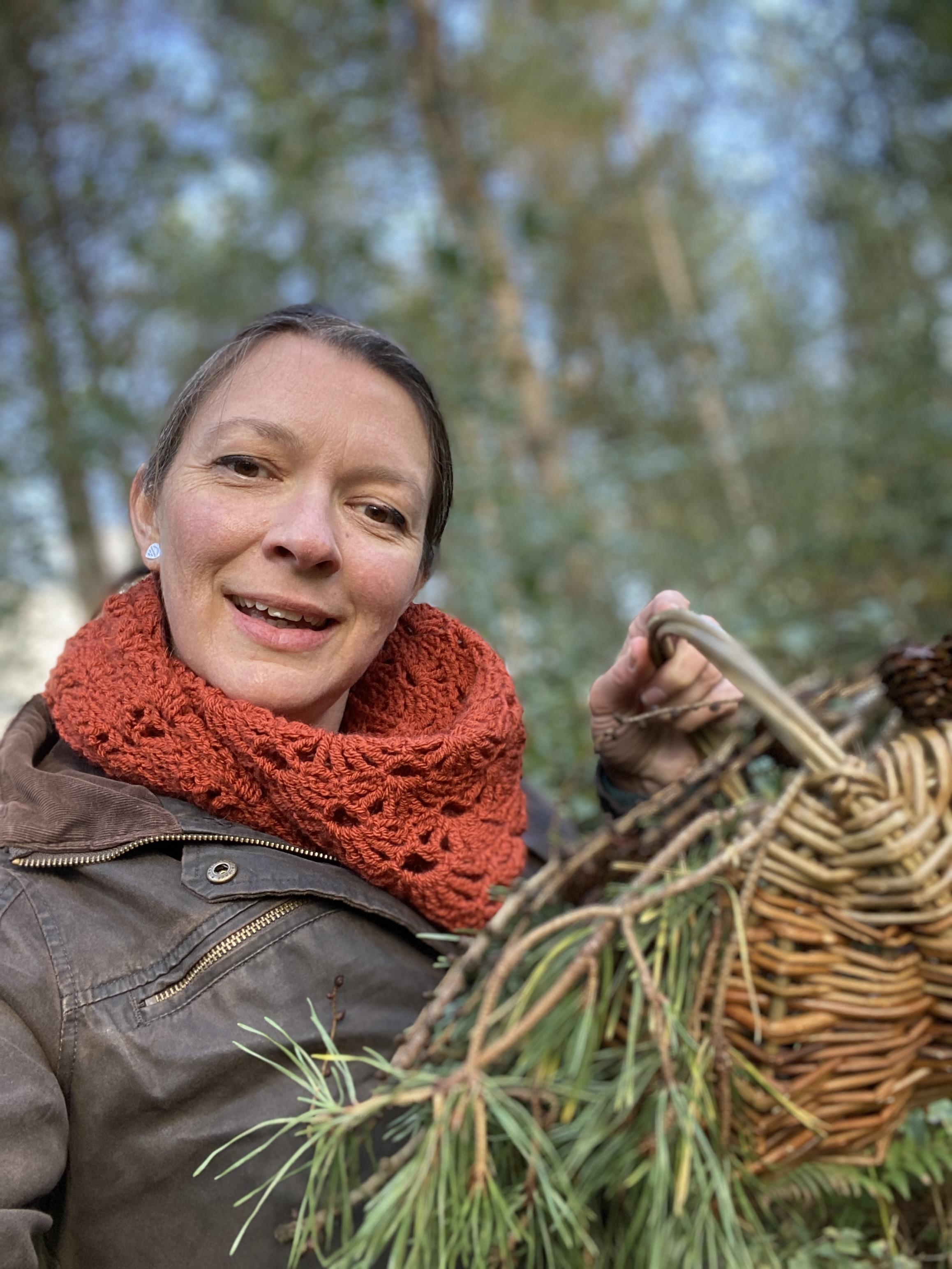 Me showing my basket with autumnal leaves, wearing the Woodbury Castle shawl