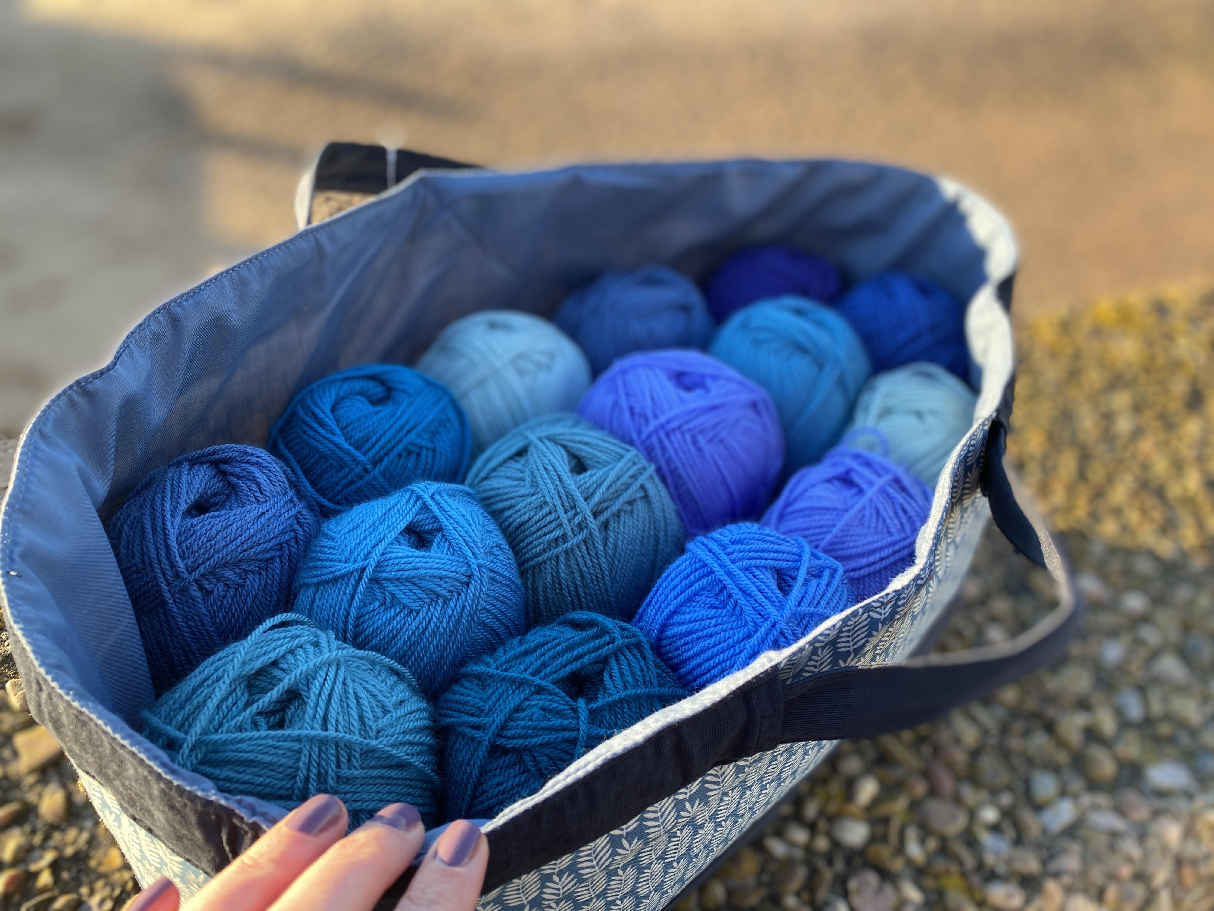 blue fern craft bag filled with 15 balls of yarn
