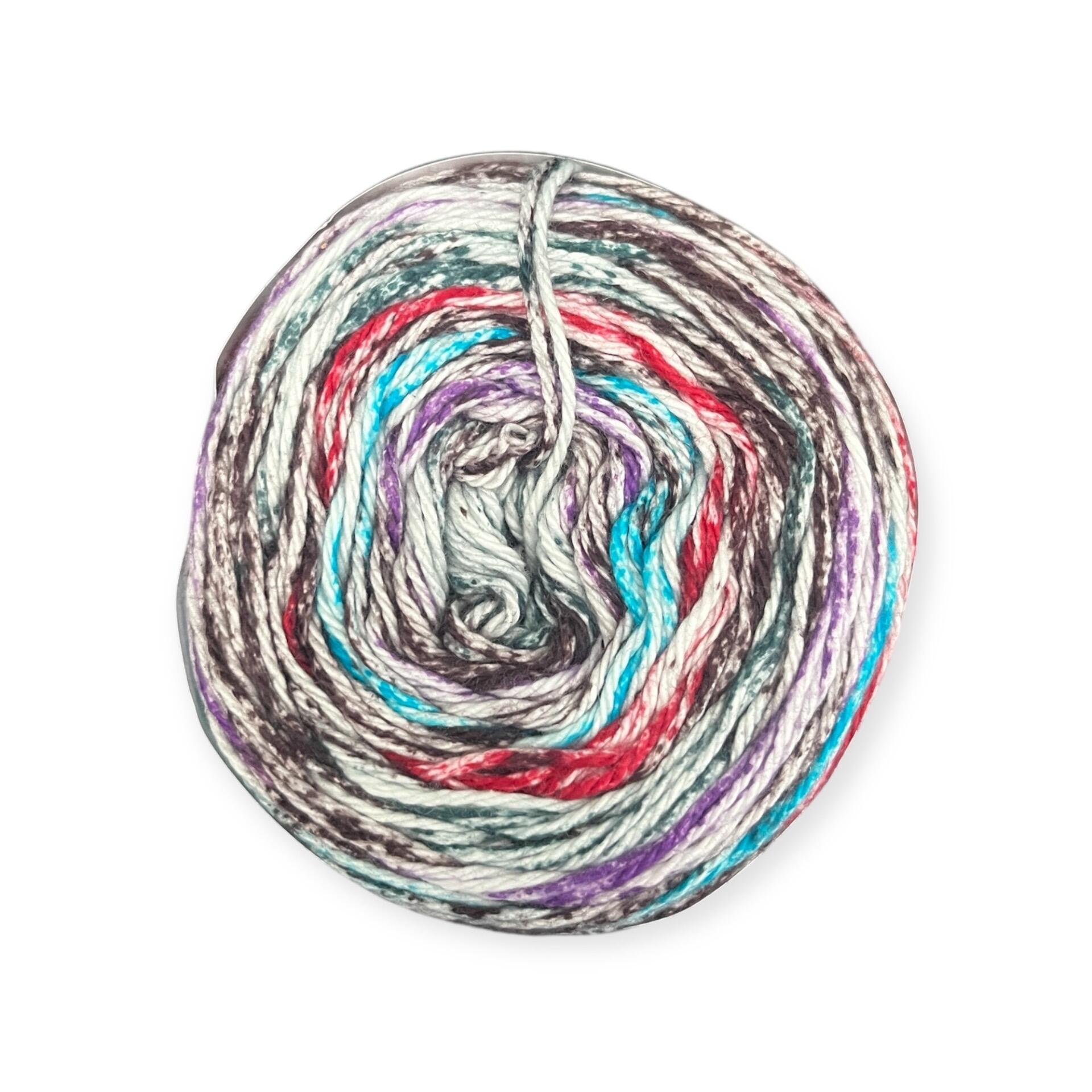 James C. Brett Cotton Waves yarn cake in Moody Skies WV10 – 100% cotton DK yarn with a rich blend of grey, red, blue, green, purple, brown, and white tones.