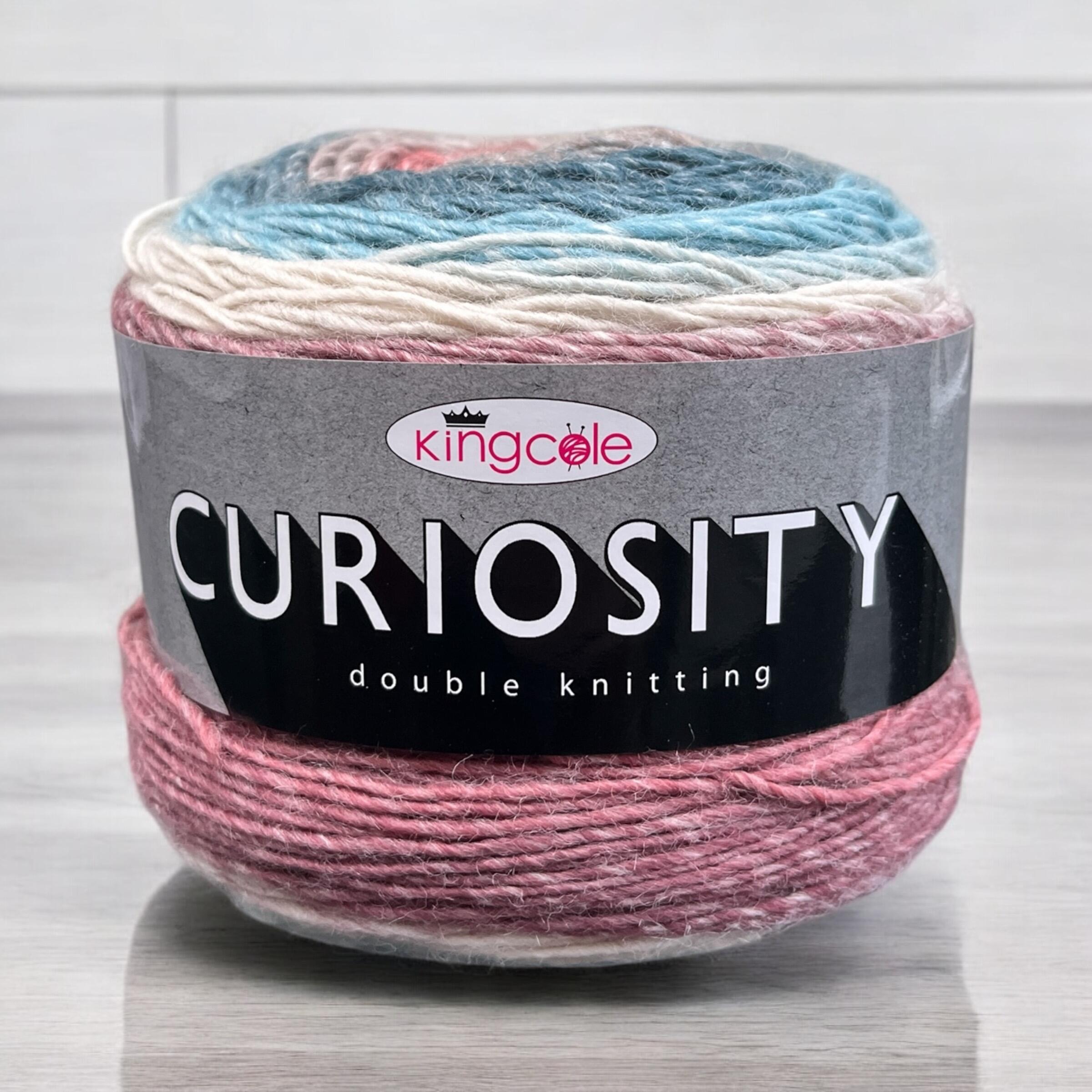 Ball of King Cole Curiosity DK yarn cake on a light wood countertop