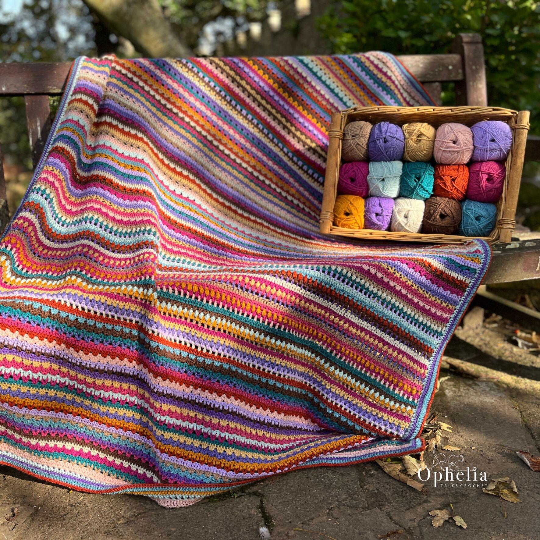 Greenway Blanket on a bench with accompanied the yarn balls in a basket