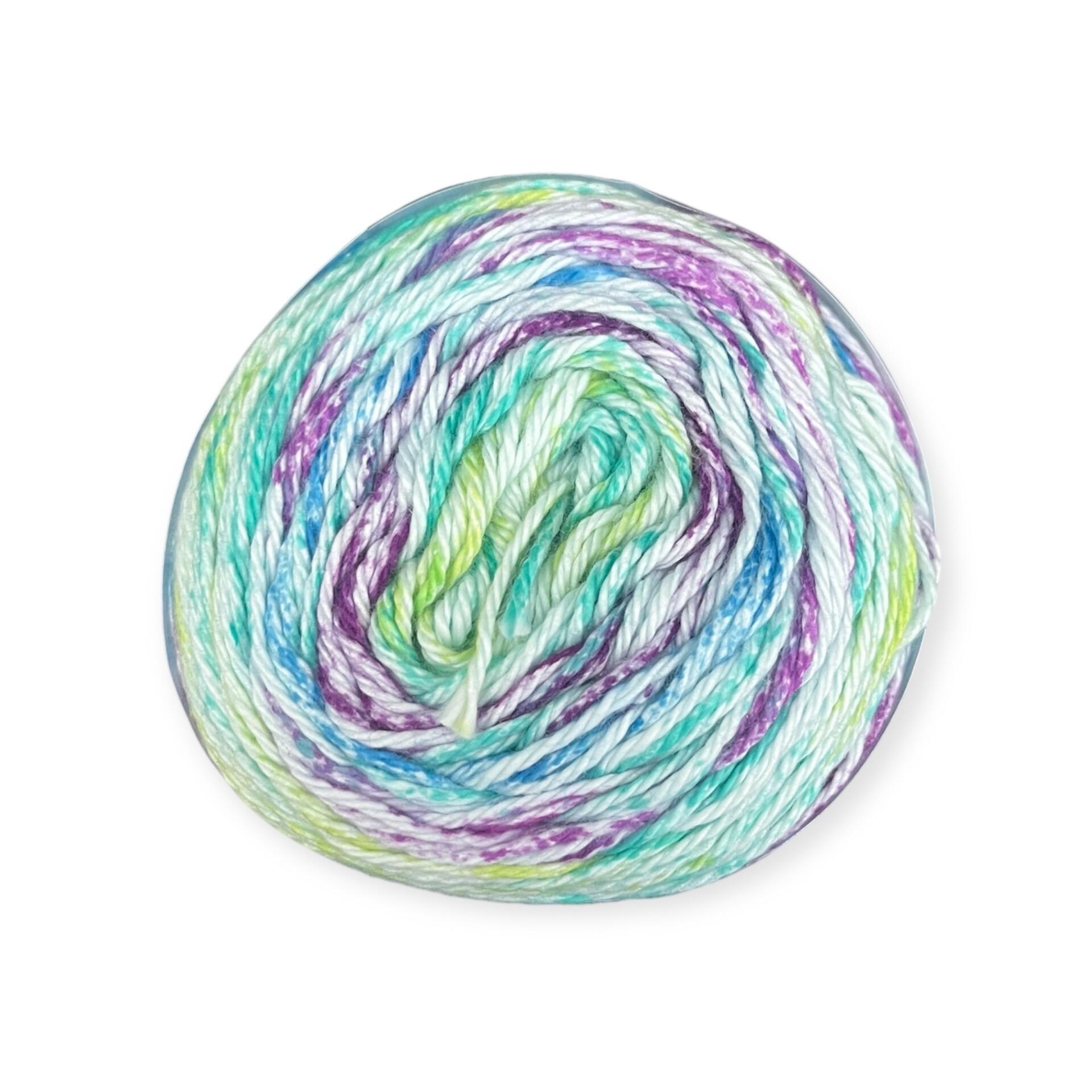 James C. Brett Cotton Waves yarn cake in Wild Orchid WV05 – 100% cotton DK yarn with blended tones of blue, green, purple, and white.