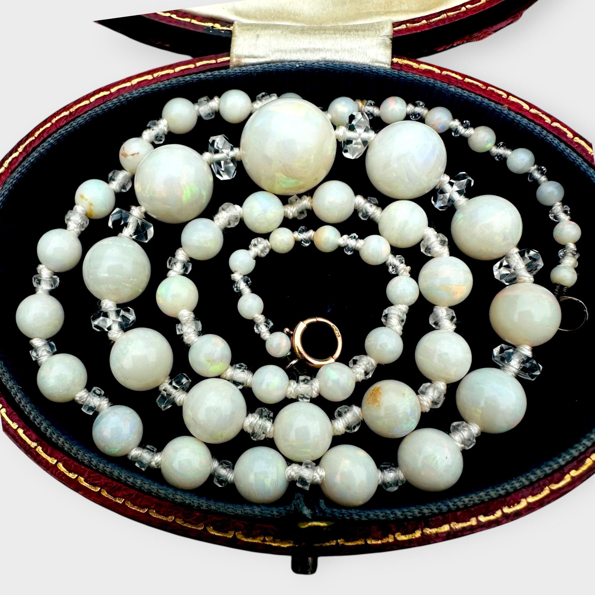 Front view of a late Edwardian opal bead necklace with graduated natural opals and rock crystal rondelles on antique box.