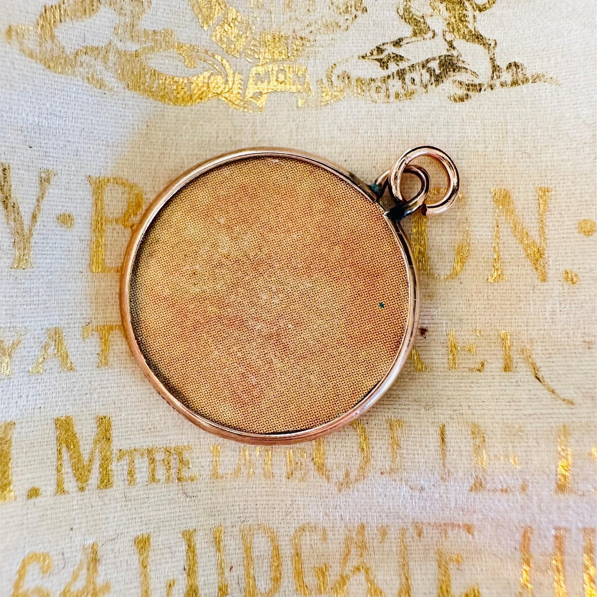 rear view of Art Nouveau Rose Gold Locket with Portrait laying on an antique box