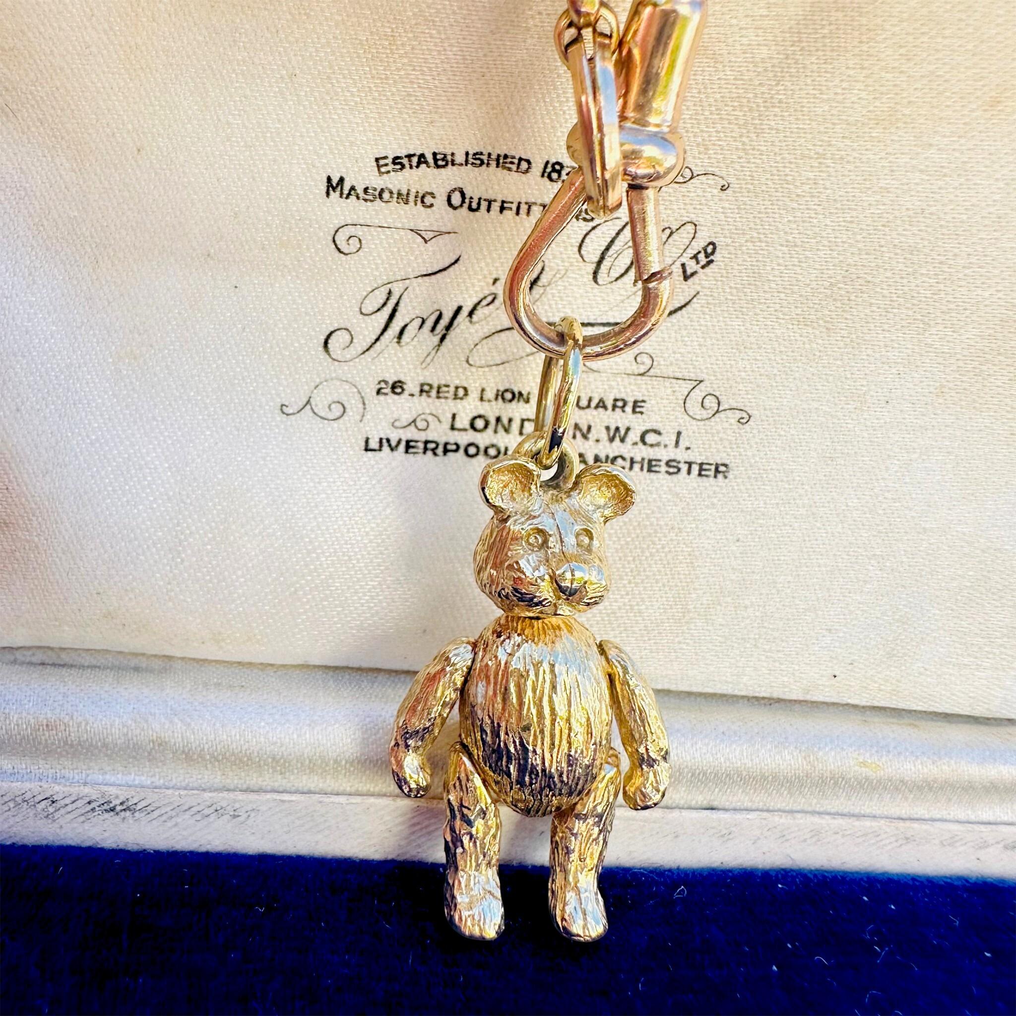 Vintage Gold Articulated Teddy Bear Charm Pendant, displayed on gold chain with antique box background