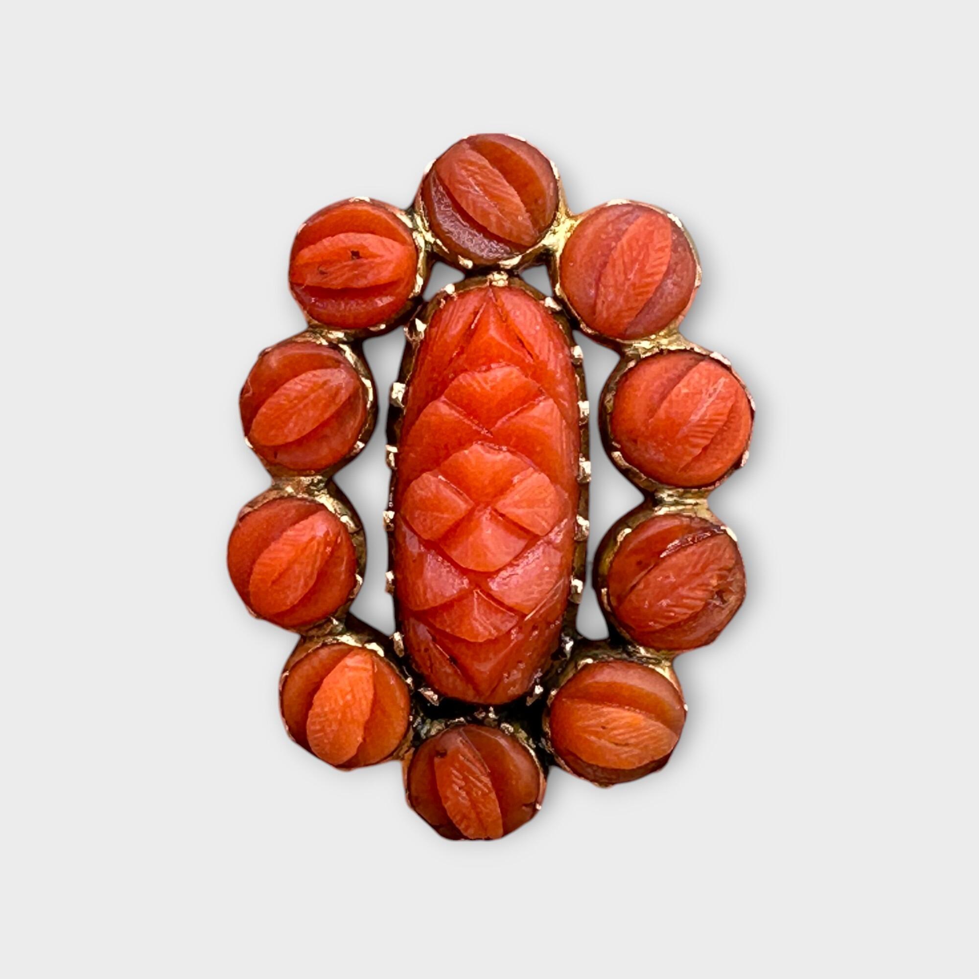 Georgian hand carved natural coral fichu brooch on grey background.