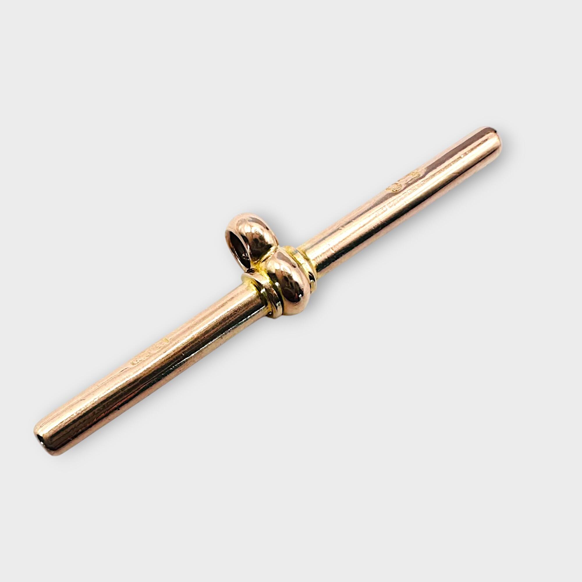 Antique, 9ct rose gold T-bar fitting on grey background.