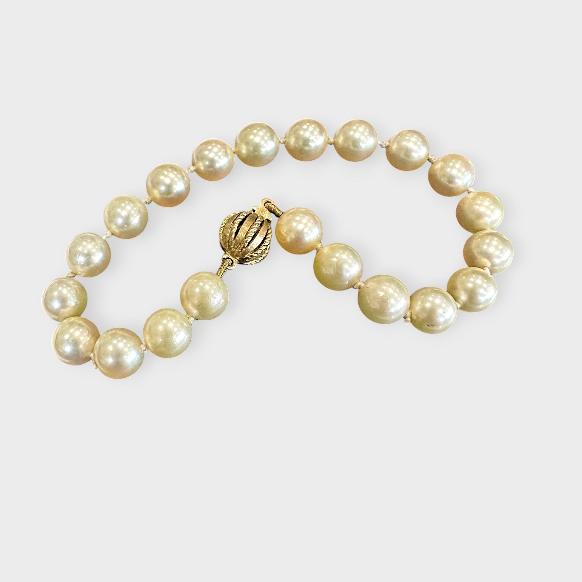 Cultured Saltwater Pearl Bracelet with 9ct Gold Ball Clasp, grey background.